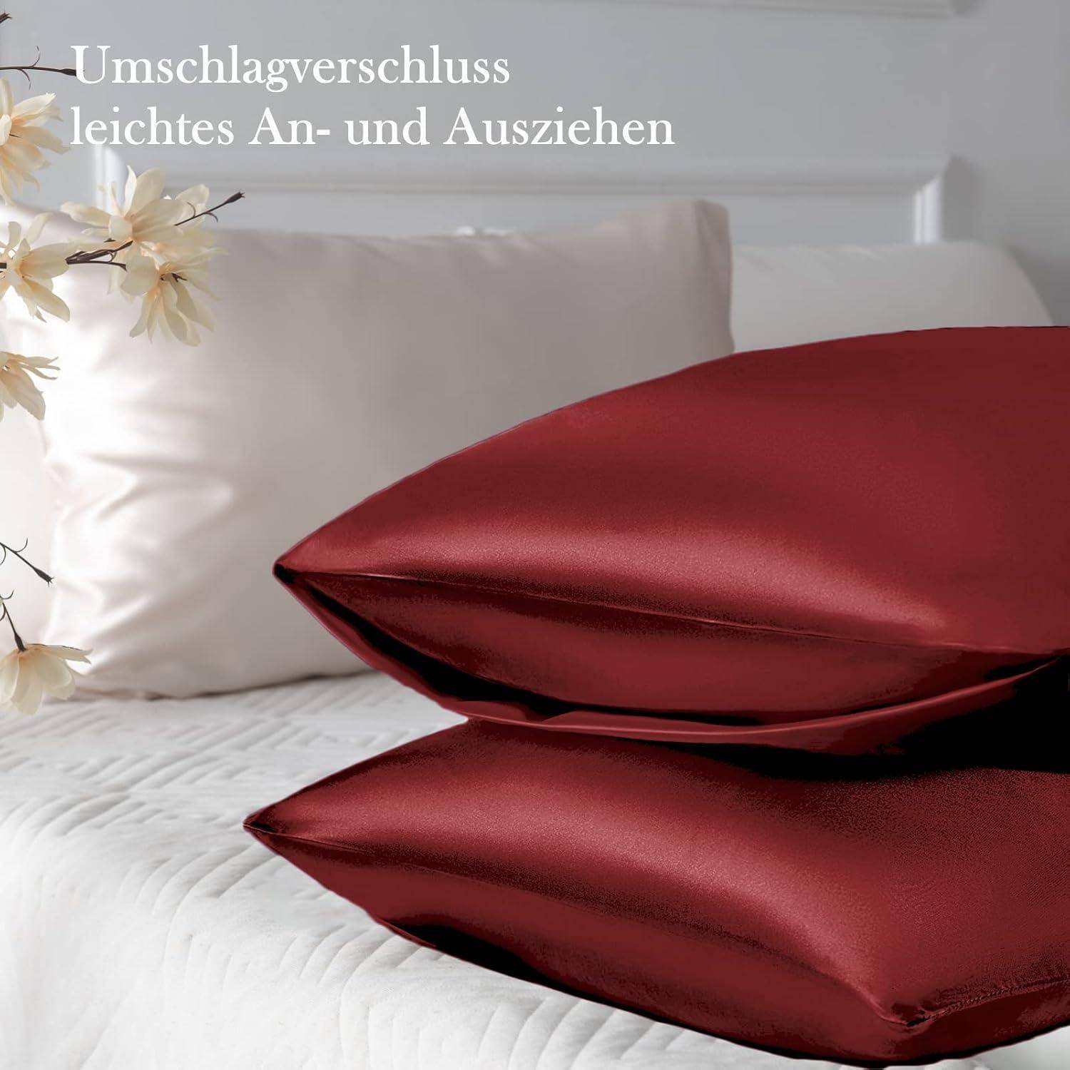 Rote Samtkissenbezüge auf einem Bett mit weißen Laken; der Text auf Deutsch lautet 'Umschlagverschluss leichtes An- und Ausziehen