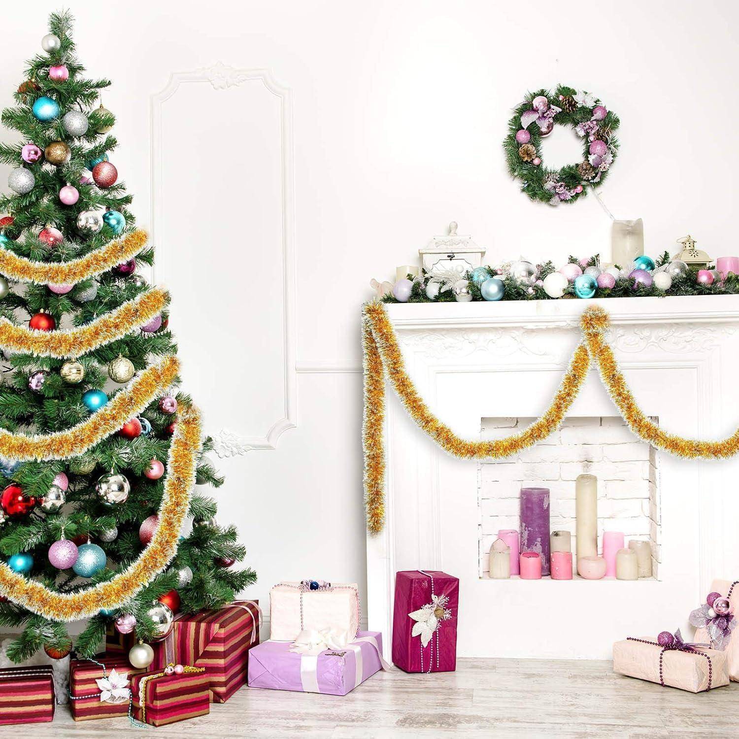 Ein geschmückter Weihnachtsbaum mit Christbaumkugeln und Geschenken steht neben einem festlich geschmückten Kamin, der mit goldenen Girlanden und einem Kranz verziert ist.