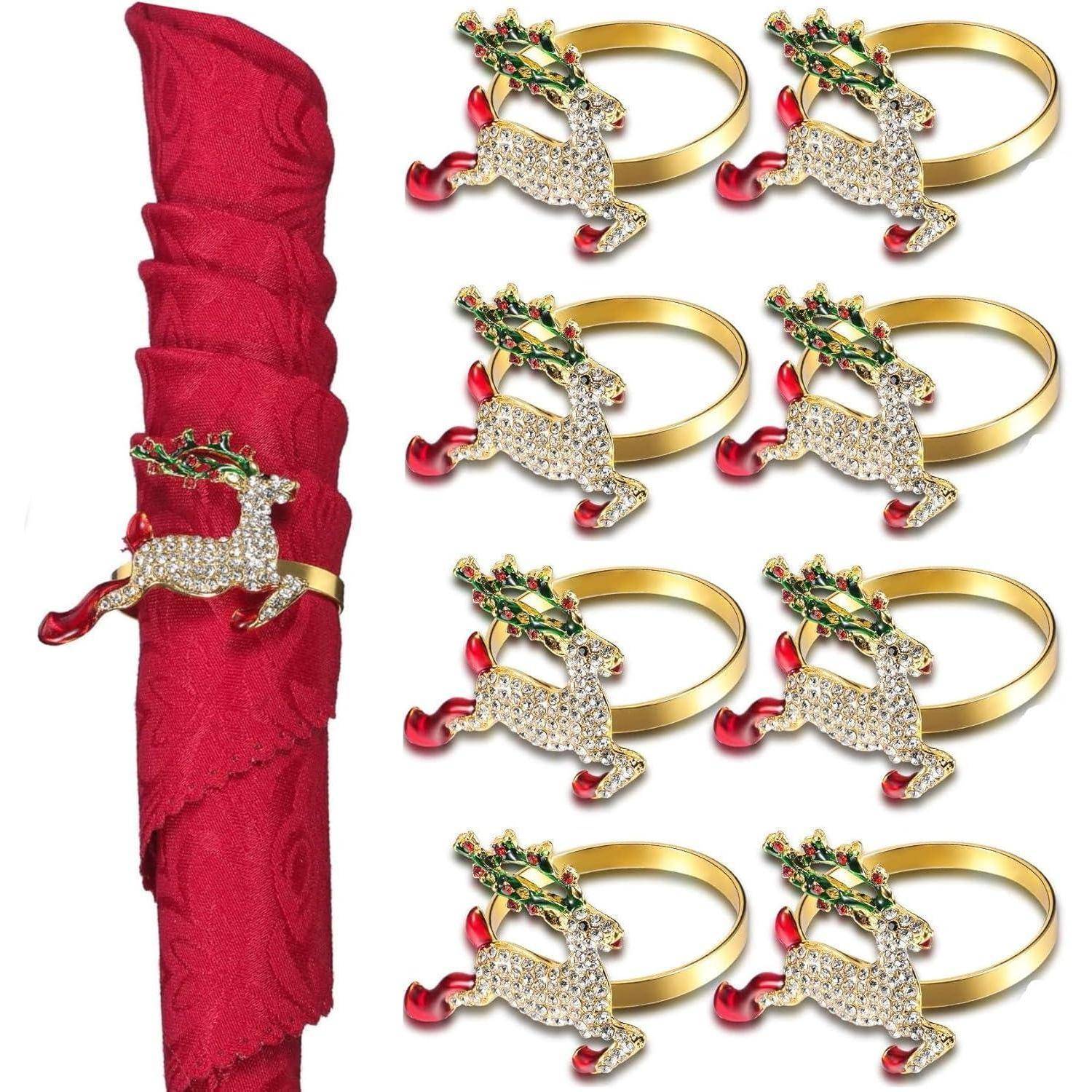 Rote Serviette mit goldenen, mit Kristallen verzierten Rentier-förmigen Ringen und grün-roten Geweihteilen; acht Serviettenringe ausgestellt.