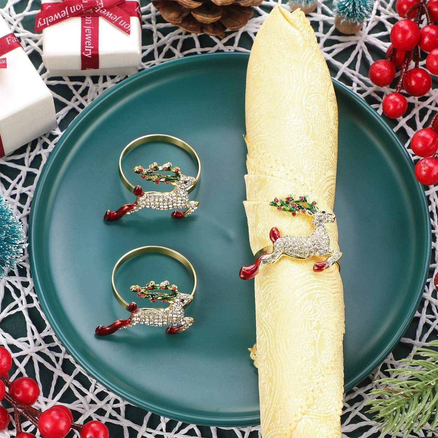 Festliche Tischdecke mit einem grünen Teller, versehen mit Servietten, die mit rentiermotivischen Serviettenringen geschmückt sind, umgeben von weihnachtlicher Dekoration.