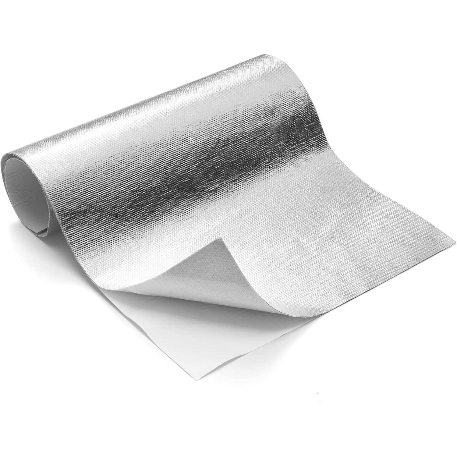 Eine Rolle reflektierender, metallischer Isolierfolie, die teilweise auf einer weißen Oberfläche ausgerollt ist und deren Textur und Flexibilität zeigt.