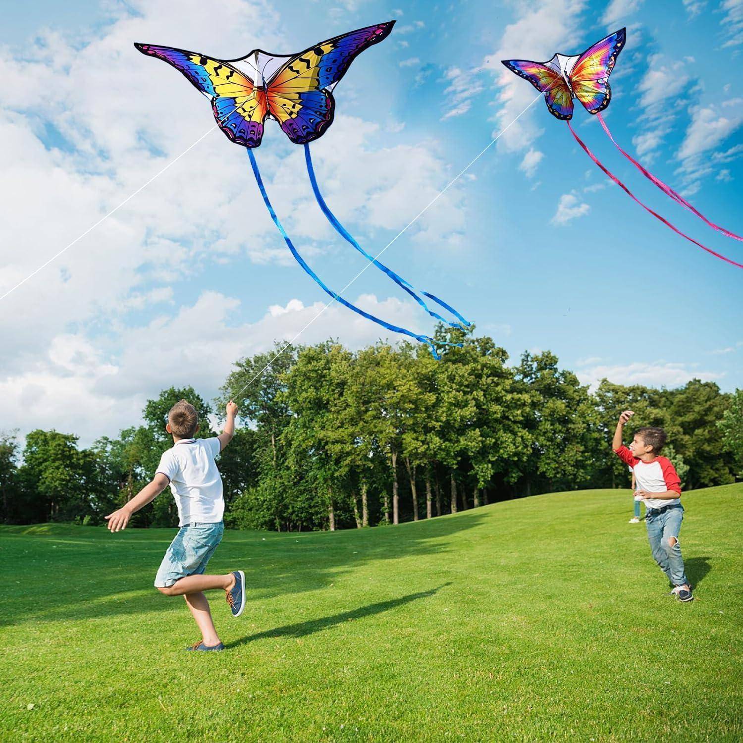 Zwei Kinder laufen auf einem grasigen Feld und lassen bunte, schmetterlingsförmige Drachen steigen, während im Hintergrund Bäume und ein blauer Himmel zu sehen sind.