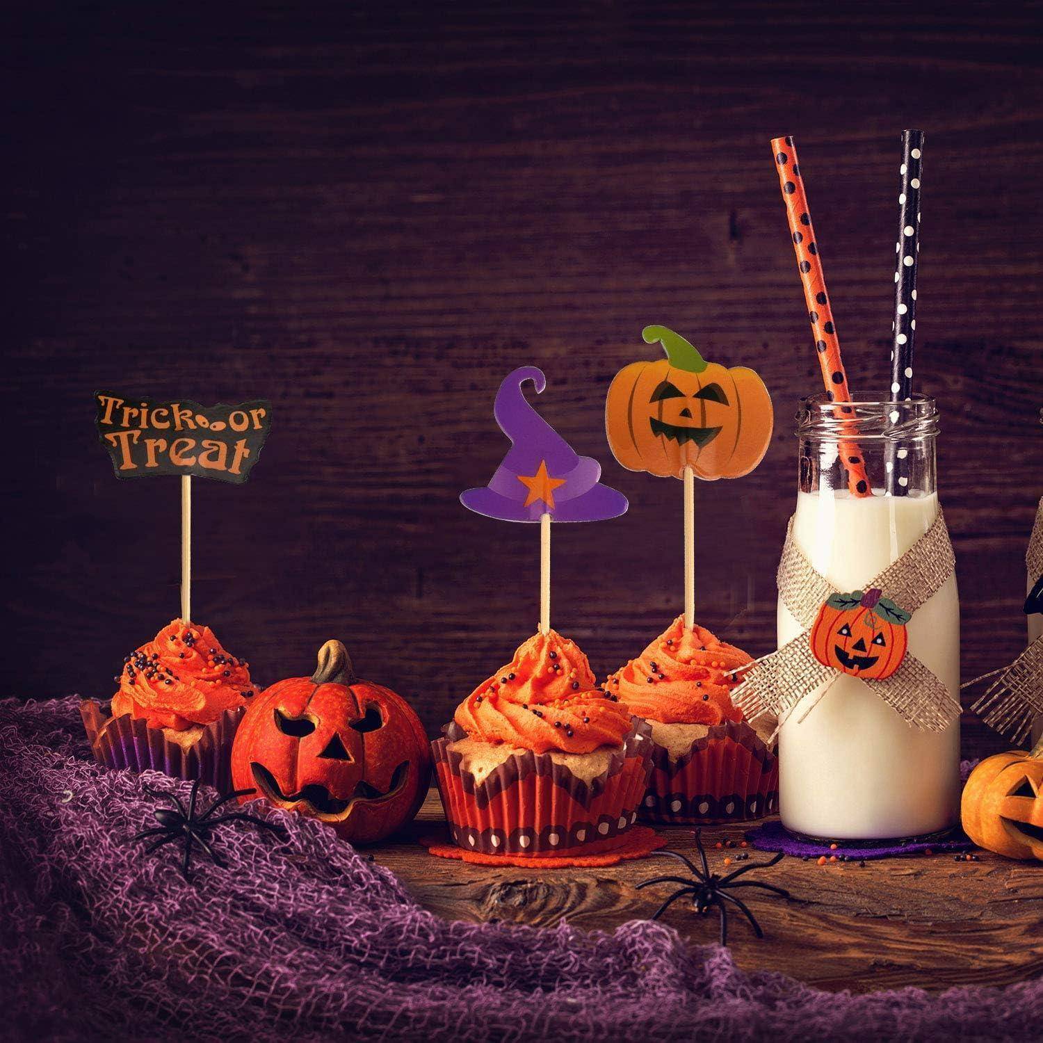 Halloween-Cupcakes mit Kürbis-Dekorationen, ein Glas Milch mit gruseligen Strohhalmen und eine Kürbisfigur vor einem lila Tuchuntergrund.