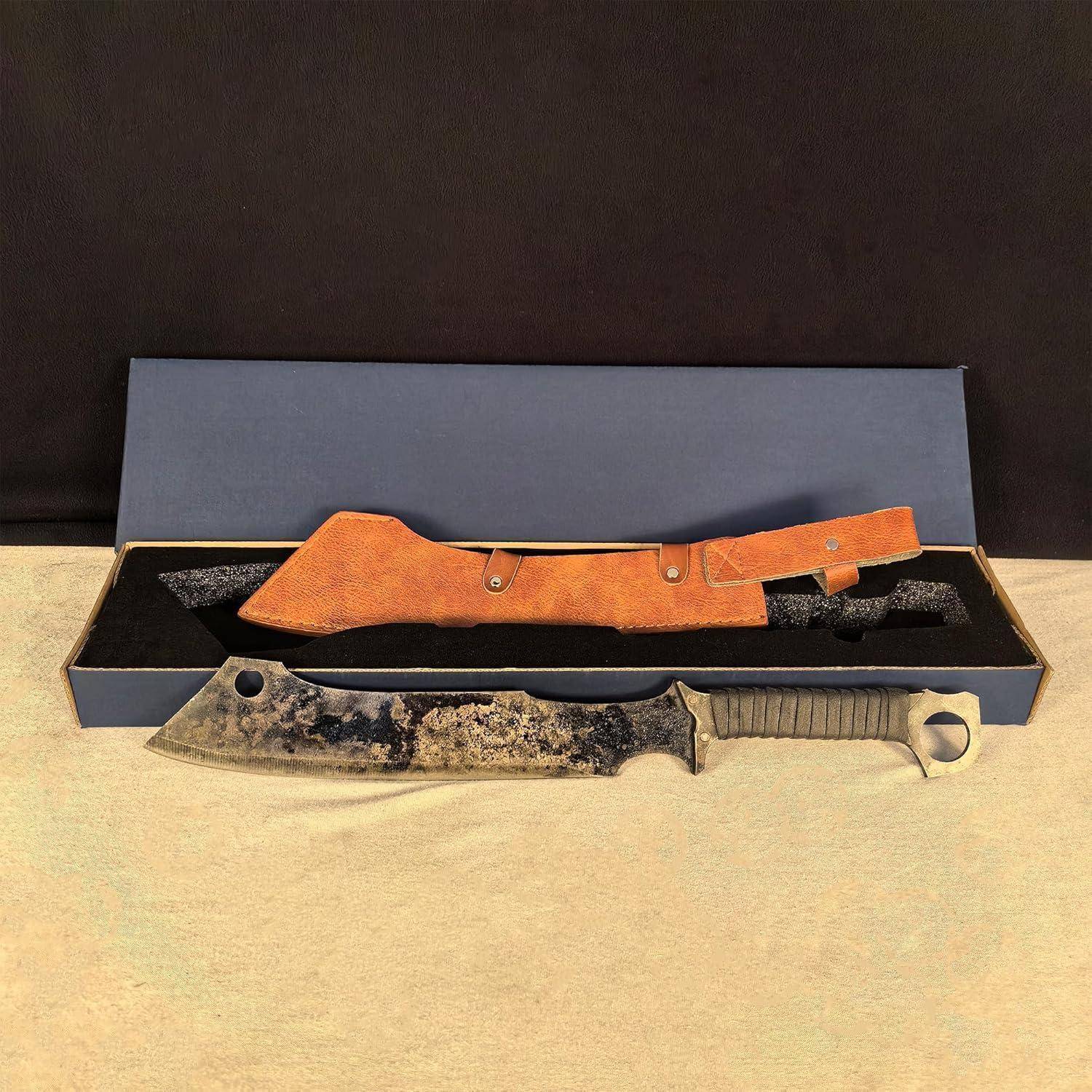 Ein großes Messer mit einer strukturierten Klinge und einem schwarzen Griff liegt vor einer geöffneten Box, die eine Lederscheide enthält.