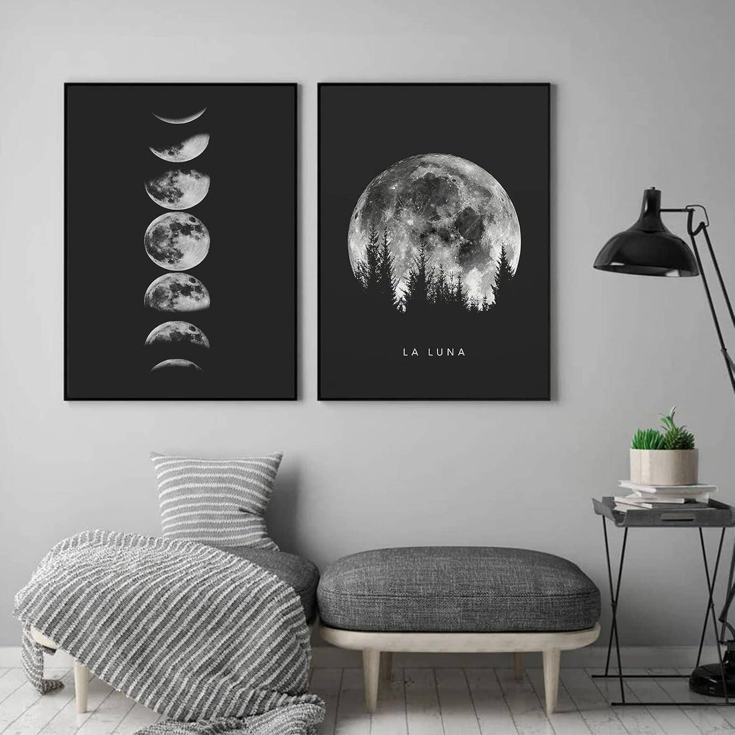 Gerahmte Kunstwerke mit Mondphasen und Vollmond mit Bäumen, die mit ‚La Luna' beschriftet sind, an einer grauen Wand; ein gemütlicher Stuhl mit einer Decke in der Nähe.