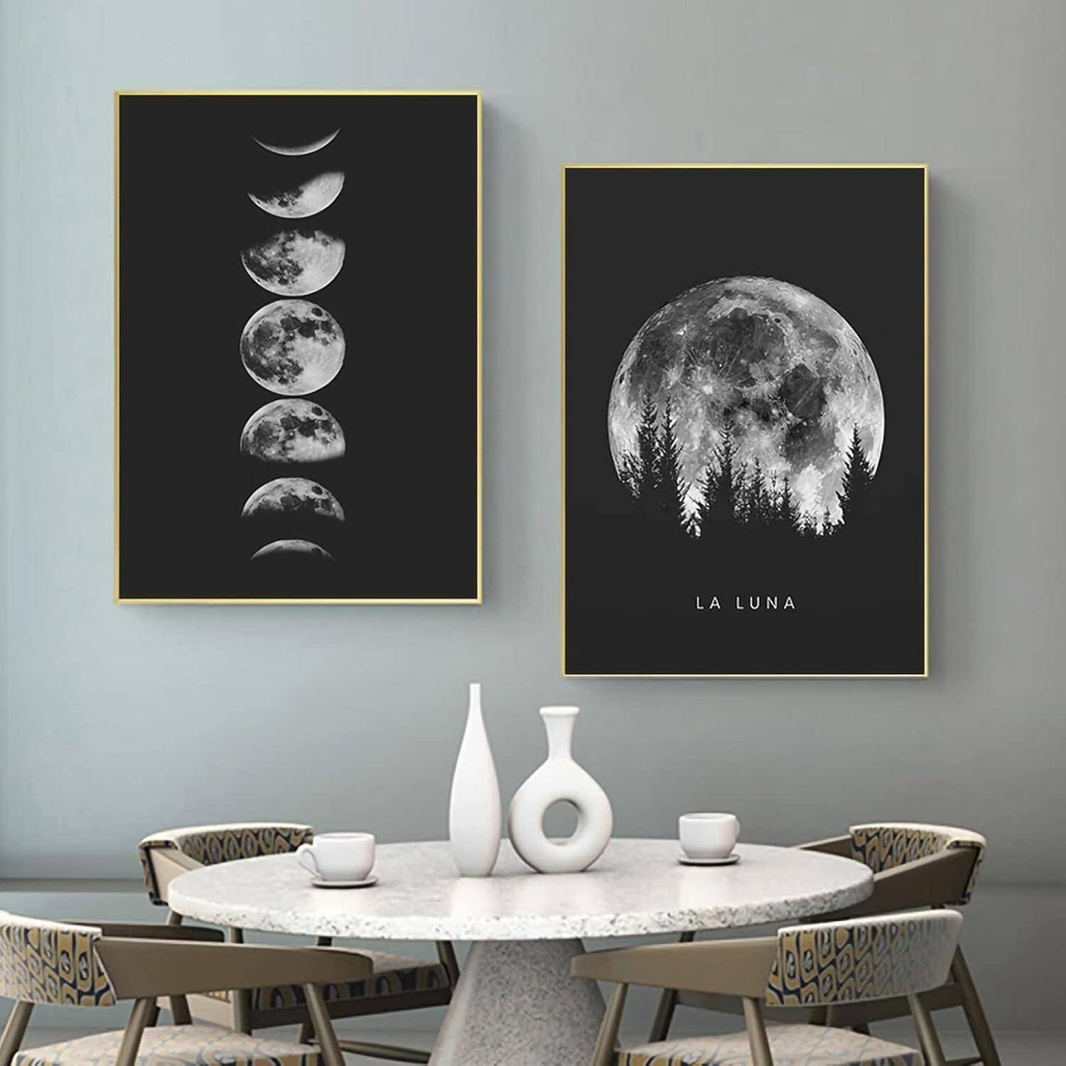 Zwei gerahmte Kunstwerke an einer grauen Wand: eines zeigt Mondphasen, das andere einen Vollmond mit Baumsilhouetten, mit der Beschriftung 