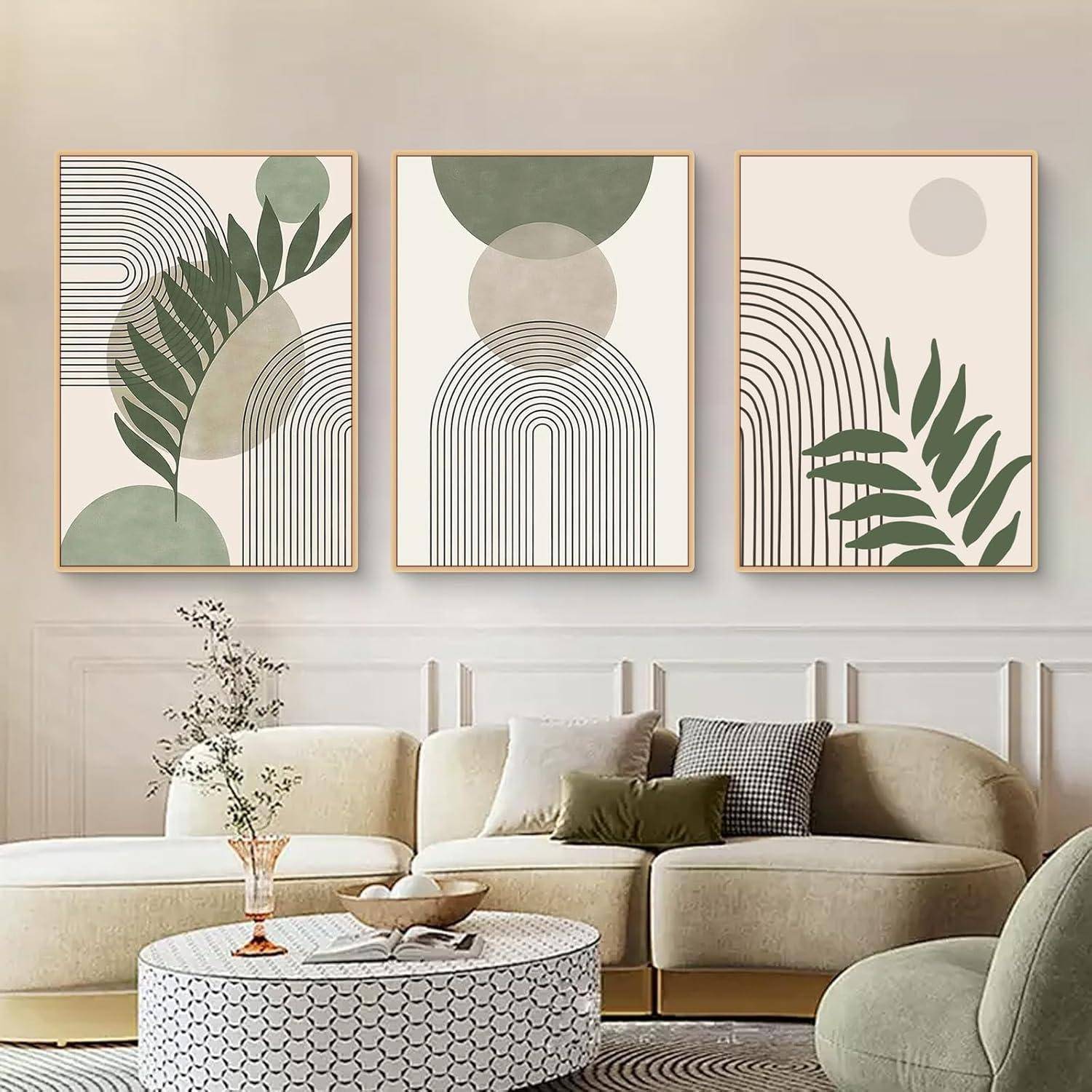 Abstrakte Kunstdrucke mit geometrischen Formen und Pflanzenmotiven hängen über einem modernen, beigen Ecksofa mit dekorativen Kissen.