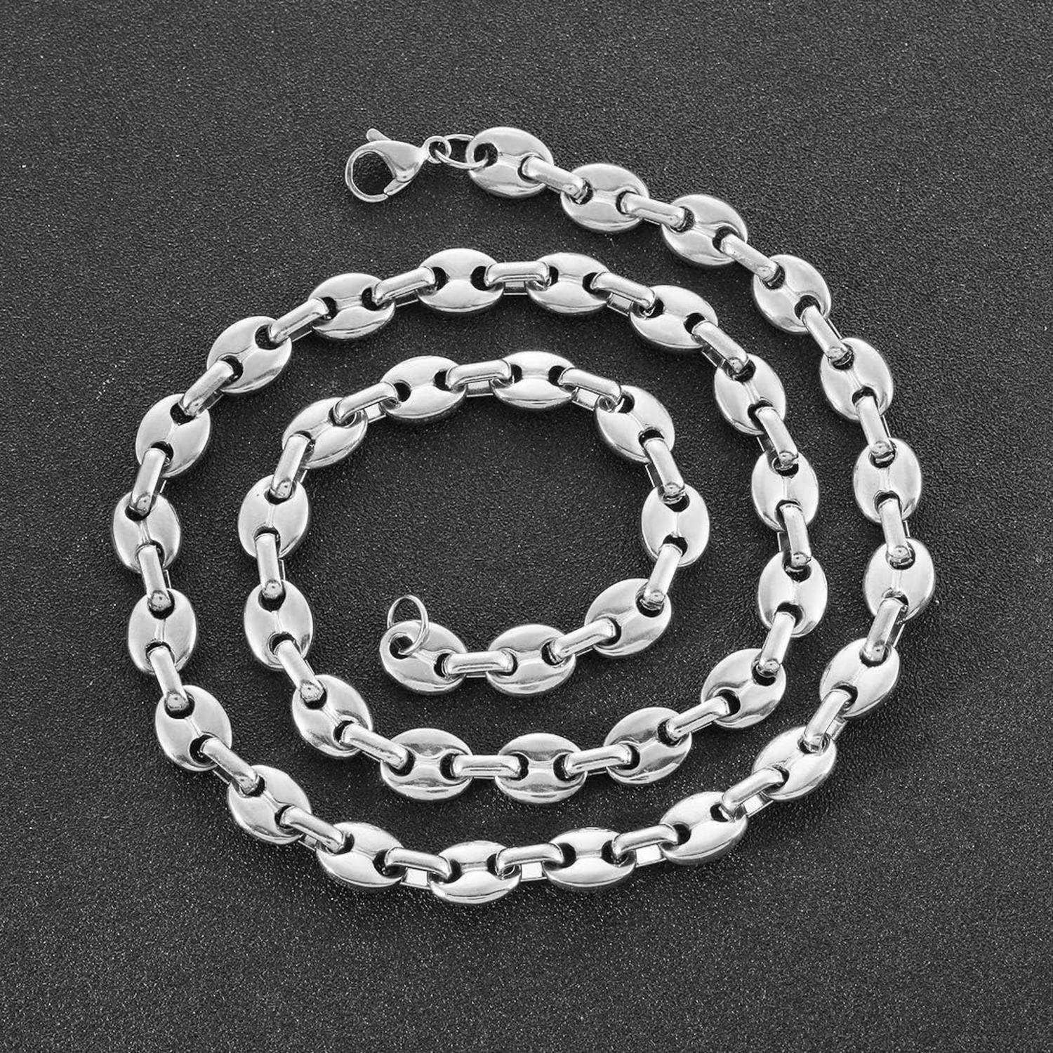 Eine Silberkette mit Armband, bestehend aus kreisförmigen Gliedern, die auf einem dunklen strukturierten Hintergrund präsentiert werden.