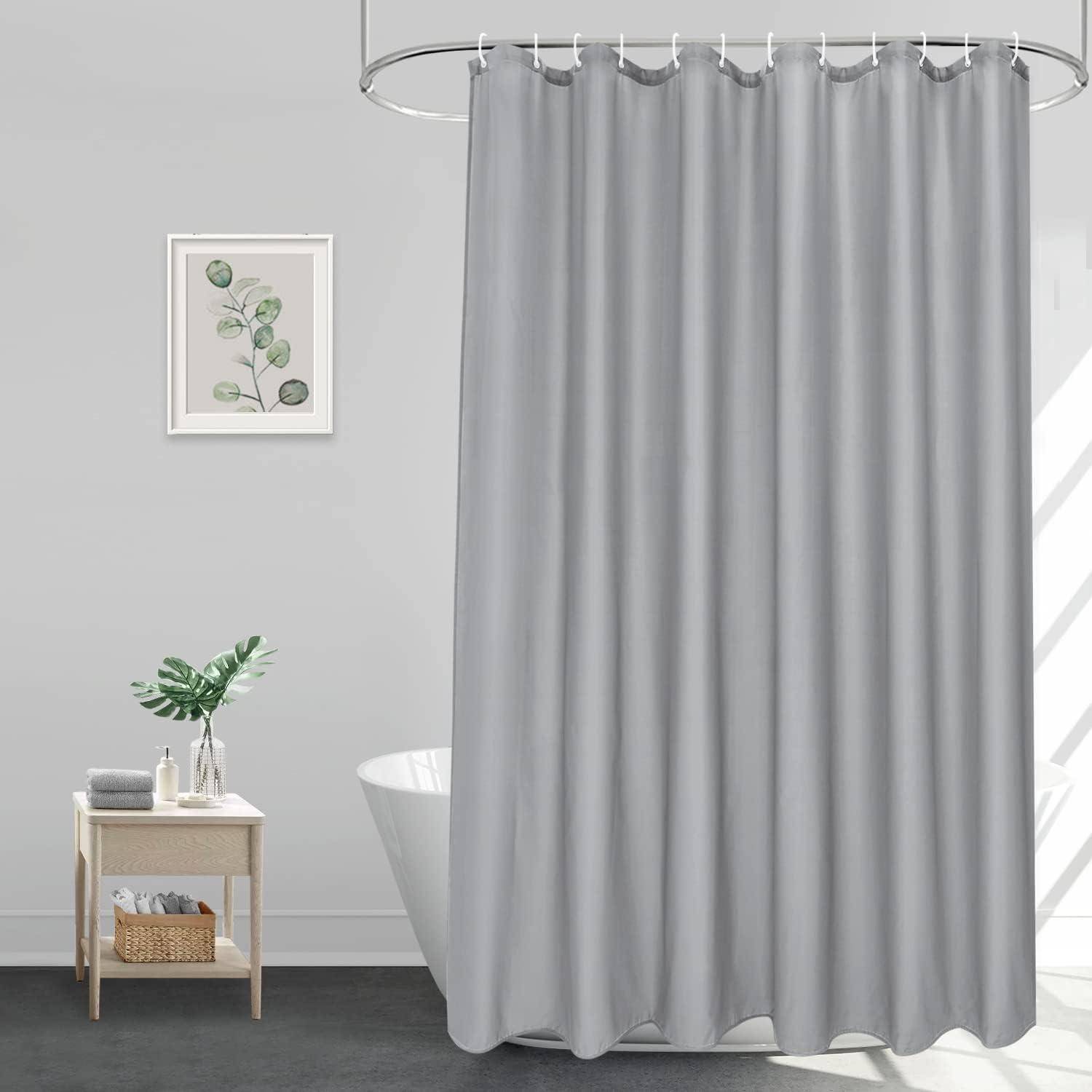 Grauer Duschvorhang in einem modernen Badezimmer. Hellgraue Wände, ein gerahmter botanischer Druck, und ein Holztisch mit einer Pflanze und Handtüchern neben einer weißen Badewanne.