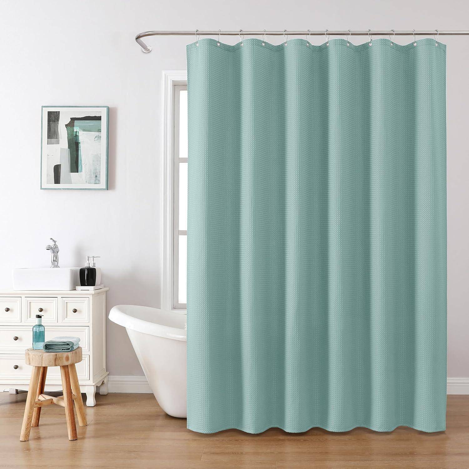 Ein Badezimmer mit einem türkisfarbenen Duschvorhang, weißer Badewanne und weißem Waschbecken. Ein Holzhocker mit Handtüchern und ein blauer Schrank mit Toilettenartikeln sind vorhanden.
