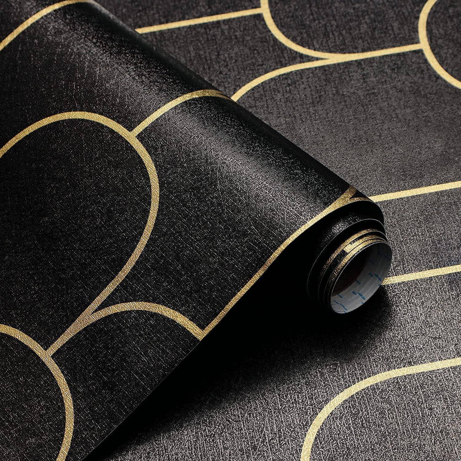 Eine Nahaufnahme einer schwarzen Tapetenbahn mit einem goldenen geometrischen Muster, das Halbkreise und Linien umfasst. Die Tapete hat eine strukturierte Oberfläche.