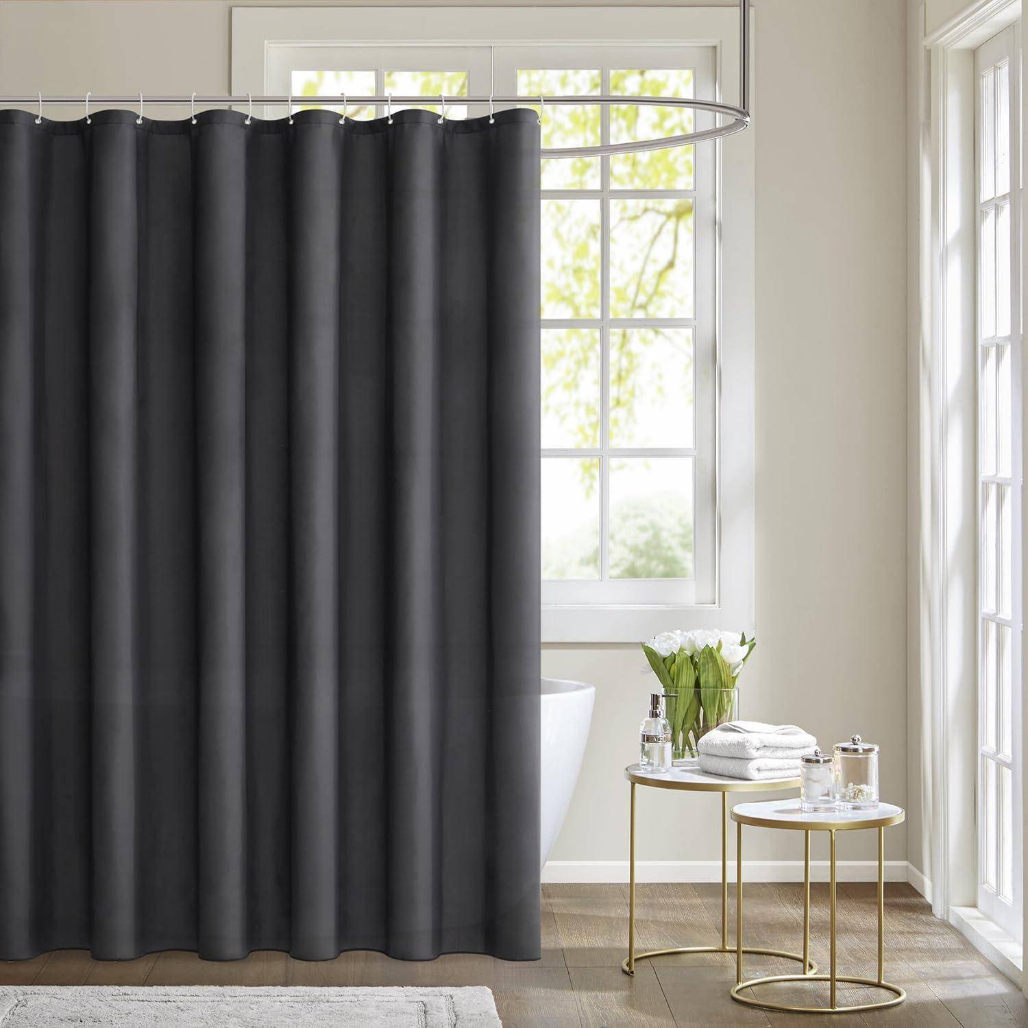 Ein Badezimmer mit einem dunkelgrauen Duschvorhang, einer teilweise sichtbaren weißen Badewanne dahinter und einem kleinen runden Tisch mit Toilettenartikeln in der Nähe.