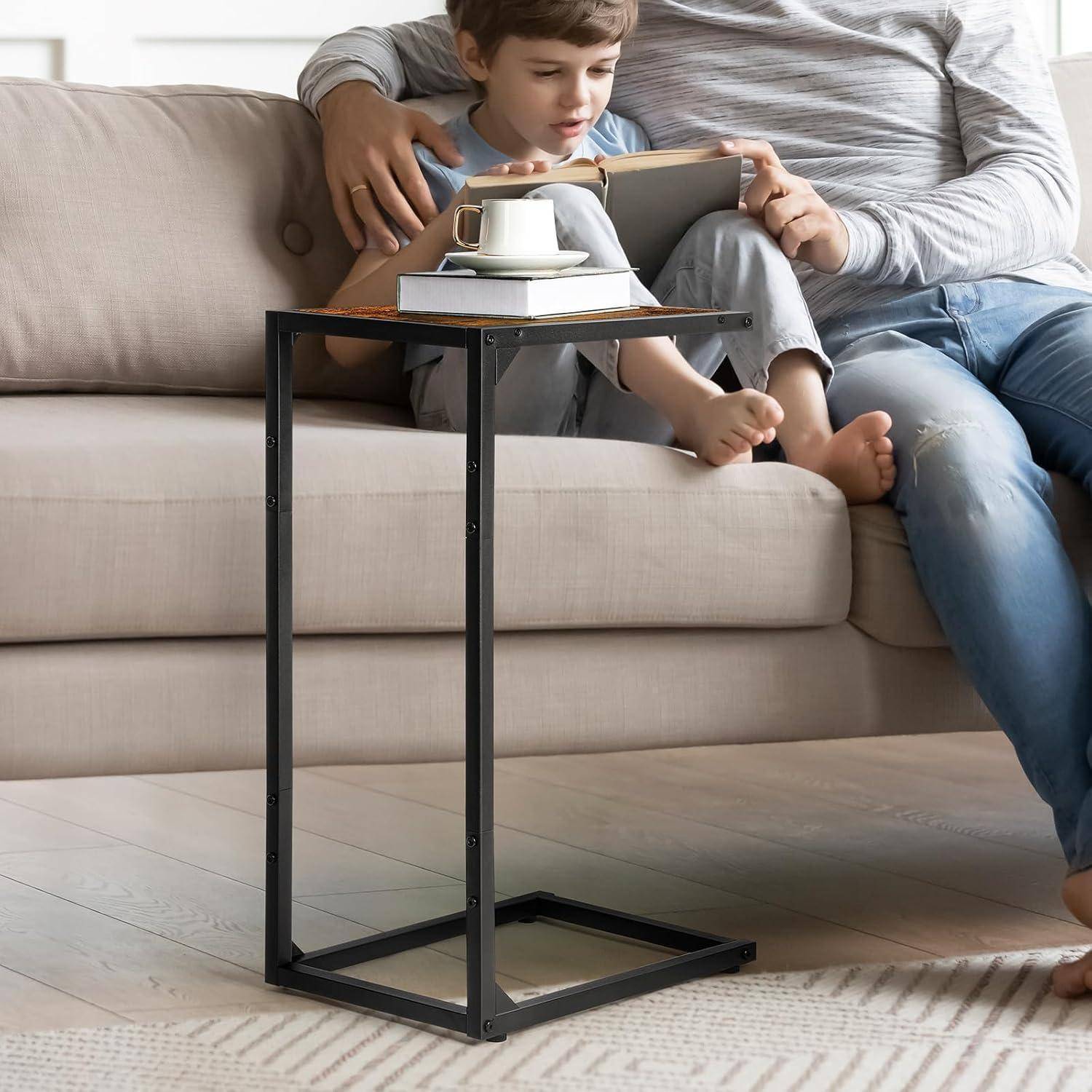 Ein Kind und ein Erwachsener sitzen zusammen auf einem Sofa und lesen ein Buch. Neben ihnen steht ein Beistelltisch mit einer Tasse. Der Raum ist hell und gemütlich.