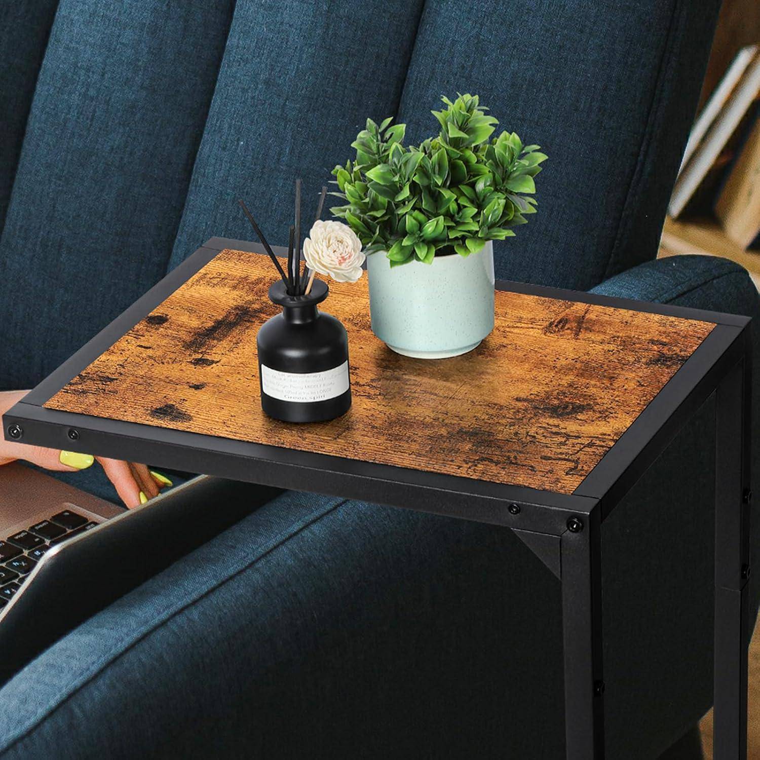 Kleiner Beistelltisch mit Holzoptik, auf dem eine Topfpflanze und ein schwarzer Diffuser stehen. Der Tisch ist neben einem blauen Sofa platziert.