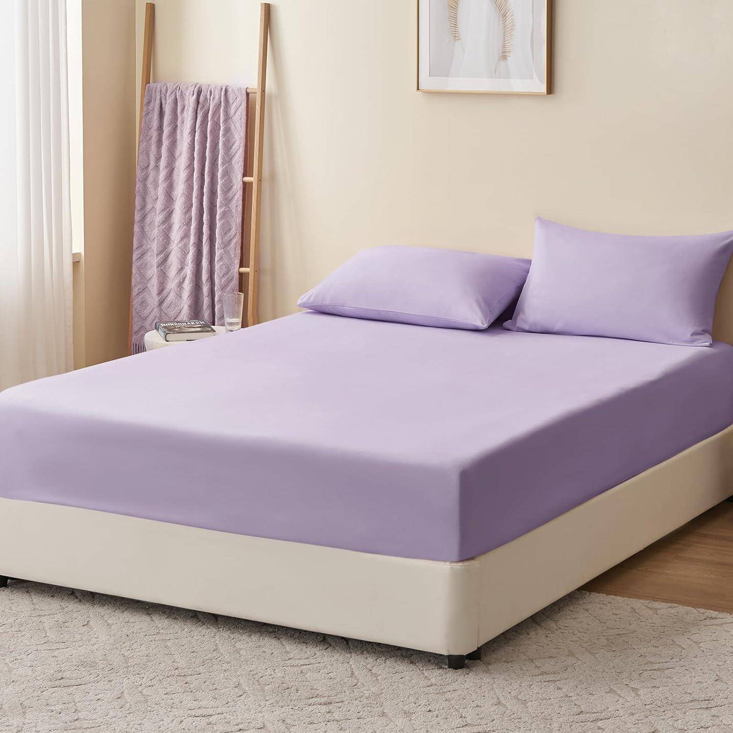 Ein sauber gemachtes Bett mit hellvioletten Betttüchern und Kissen steht neben einem Fenster. Eine Holzleiter hält eine Steppdecke, und ein kleiner Beistelltisch befindet sich in der Nähe.