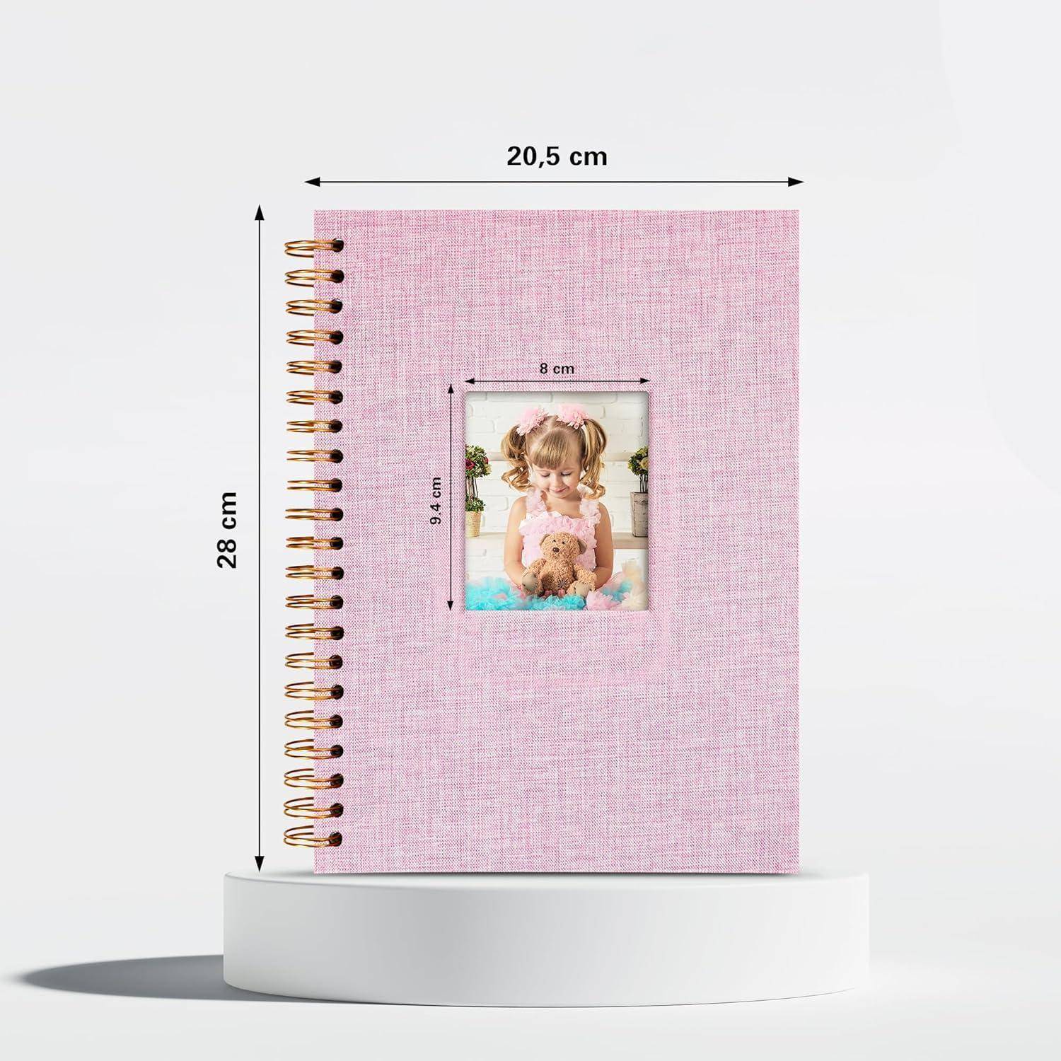 Ein rosafarbenes Spiralgebundenes Notizbuch mit einem Titelfoto, das ein Kind zeigt, das einen Teddybären umarmt. Das Notizbuch ist 28 cm hoch und 20,5 cm breit.