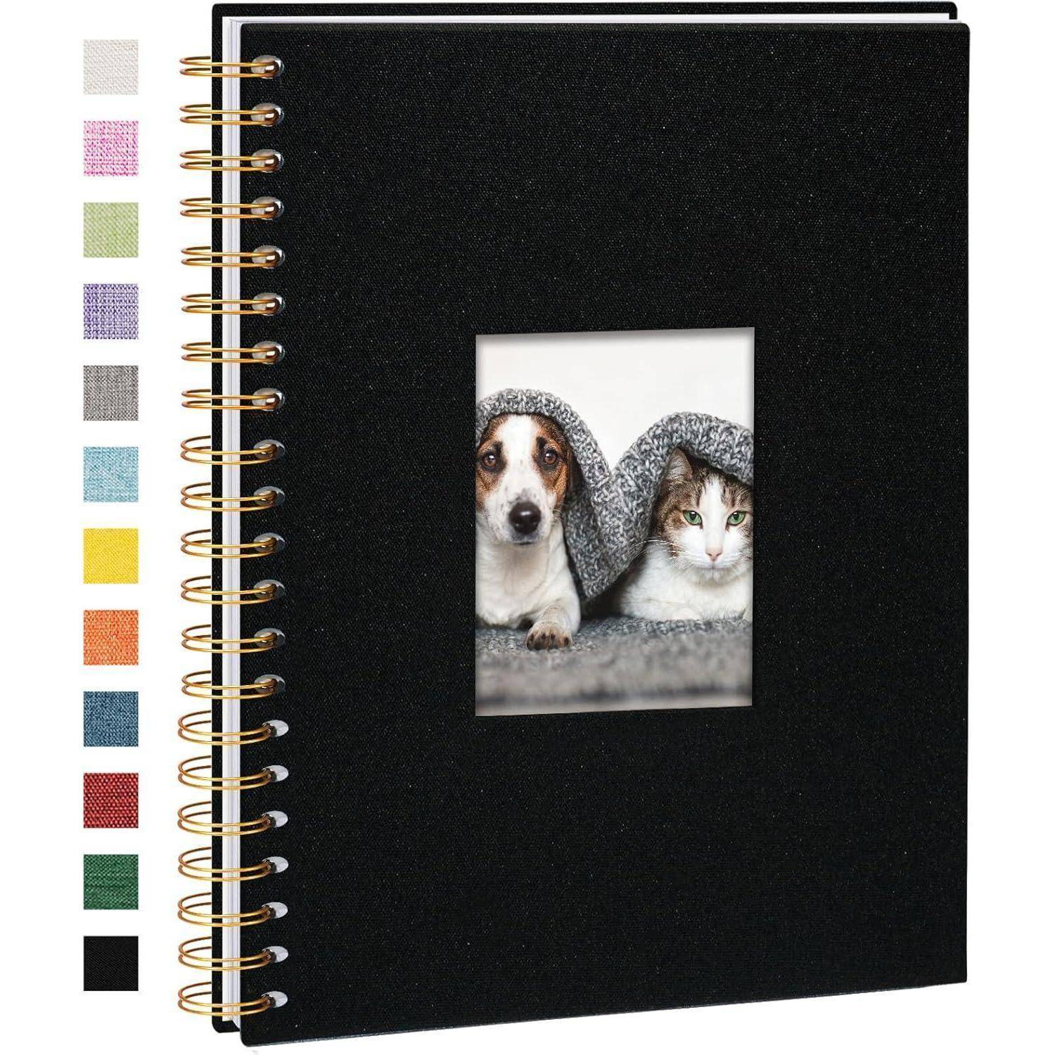 Ein schwarzes spiralgebundenes Notizbuch mit einem Coverbild eines Hundes und einer Katze unter einer Decke. Farbfelder sind entlang der linken Seite dargestellt.