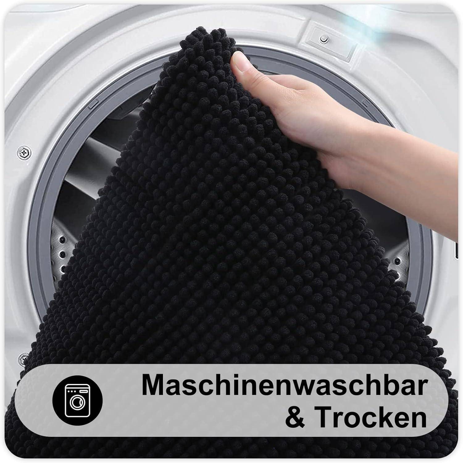Eine Hand legt eine strukturierte schwarze Matte in eine Waschmaschine. Der Text unten lautet: 'Maschinenwaschbar & Trocken' und zeigt an, dass der Gegenstand maschinell waschbar und trocknungsfähig ist.