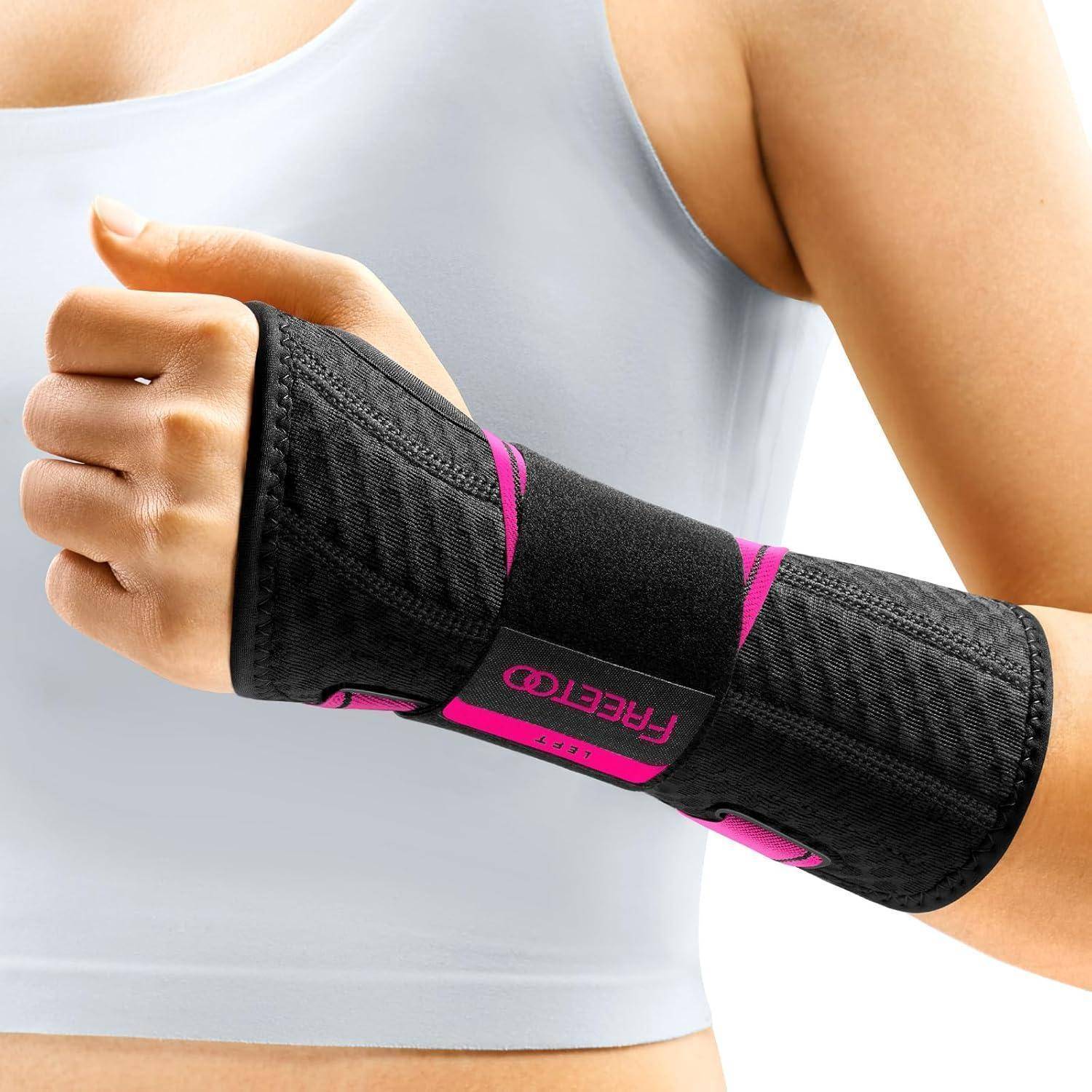 Eine Person, die eine schwarze Handgelenkbandage mit rosa Akzenten am rechten Handgelenk trägt. Die Person ist in einem weißen Trägertop gekleidet.