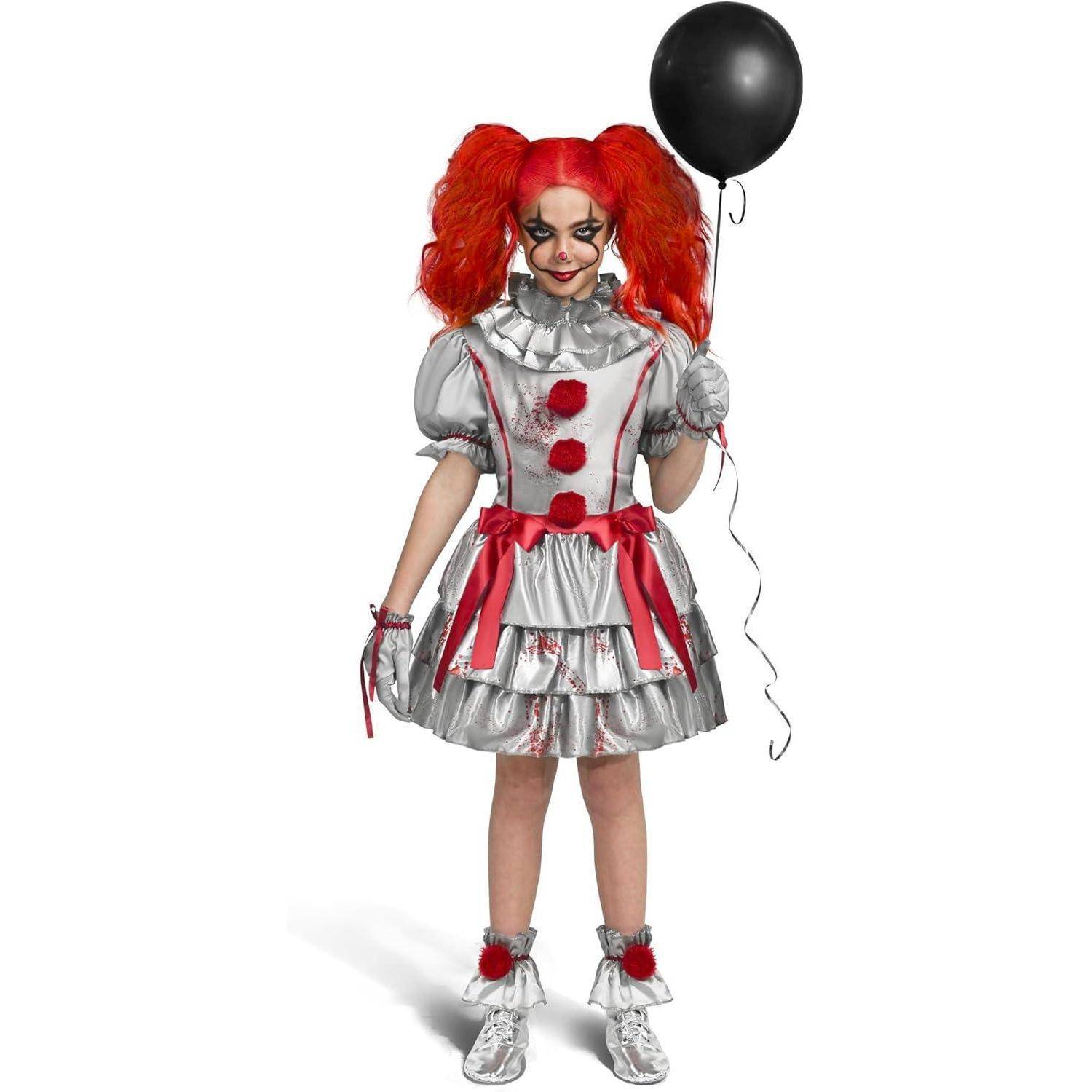 Eine Person in einem silbernen Clownskostüm mit roten Akzenten, die einen schwarzen Luftballon hält. Sie hat rote Haare und Schminkung im Clown-Stil.
