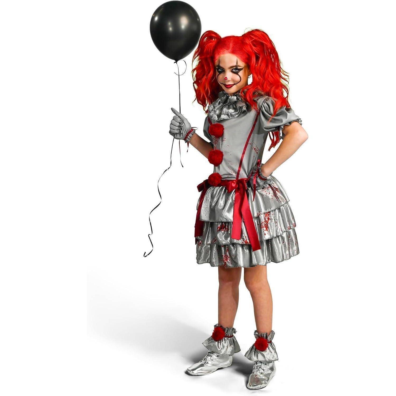 Eine Person in einem silbernen Clownskostüm mit roten Haaren und einem roten Band, die einen schwarzen Luftballon hält. Der Ausdruck wirkt verspielt.