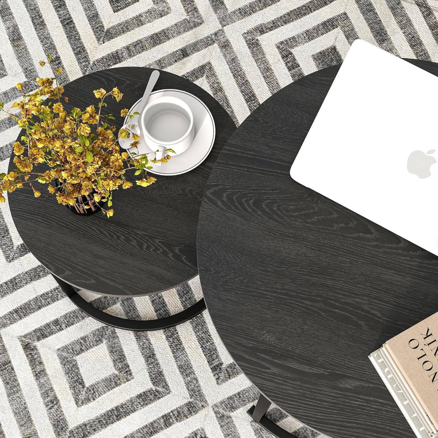 Ein moderner Arbeitsbereich mit einem schwarzen Tisch, auf dem ein Laptop, ein Notizbuch und eine Blumenvase stehen, vor einem geometrisch gemusterten Teppich im Hintergrund.