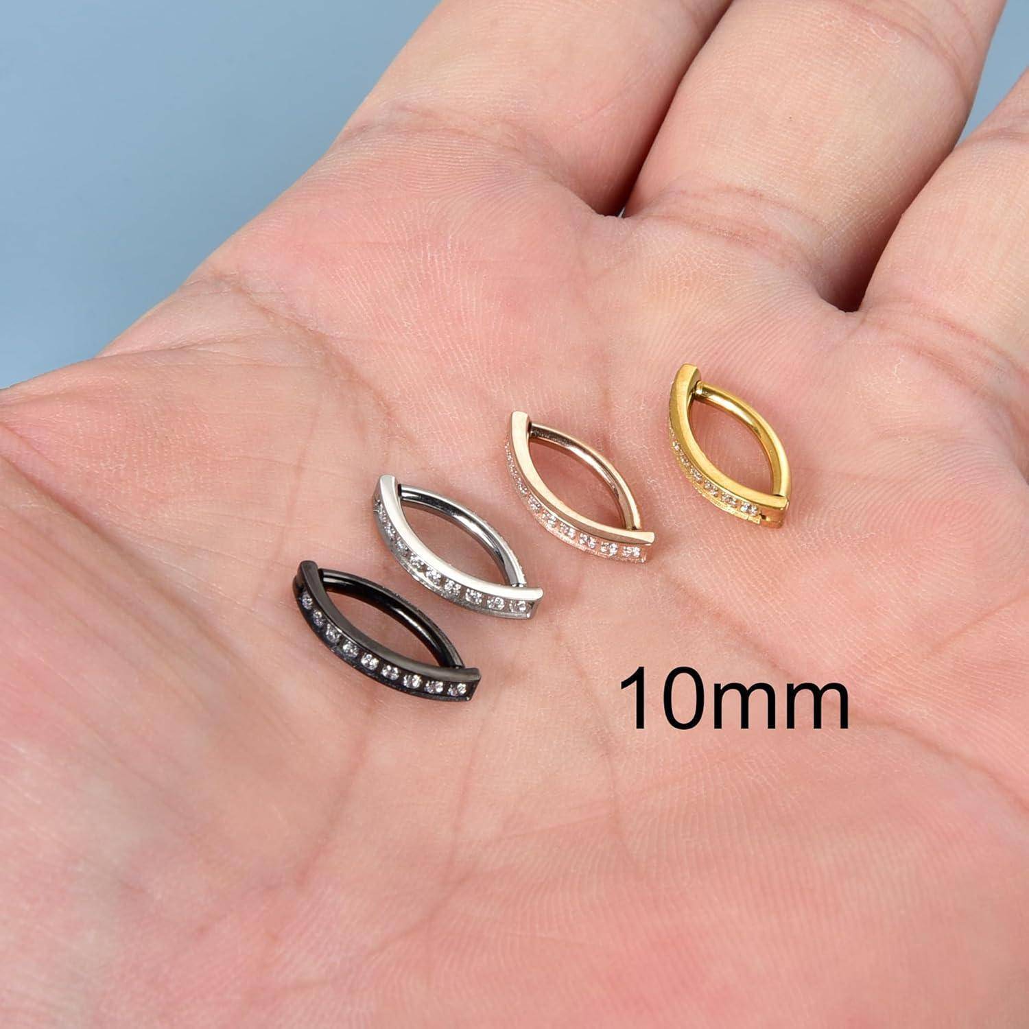 Eine Hand hält vier kleine Ringe in Silber, Gold und Schwarz mit eingesetzten Steinen. Der Text liest sich '10mm' und gibt die Ringgröße an.
