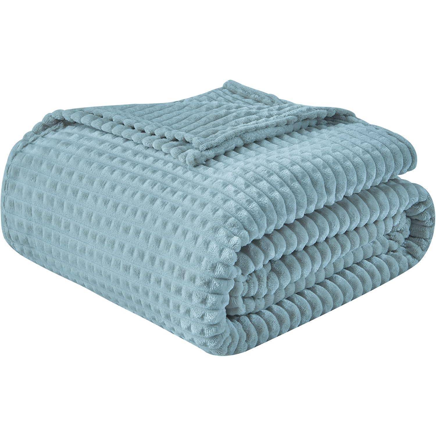 Eine gefaltete, strukturierte, hellblaue Decke, die ihr Waffelmuster präsentiert.