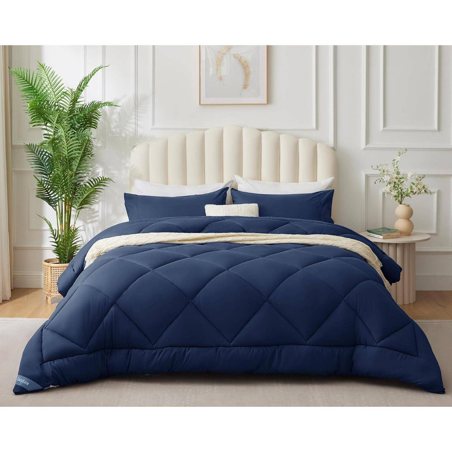 Ein ordentlich gemachtes Bett mit einer marineblau-farbenen Bettdecke, einem beige Kopfteil und marineblau-beigen Kissen. Eine Pflanze und eine dekorative Vase stehen neben dem Bett.
