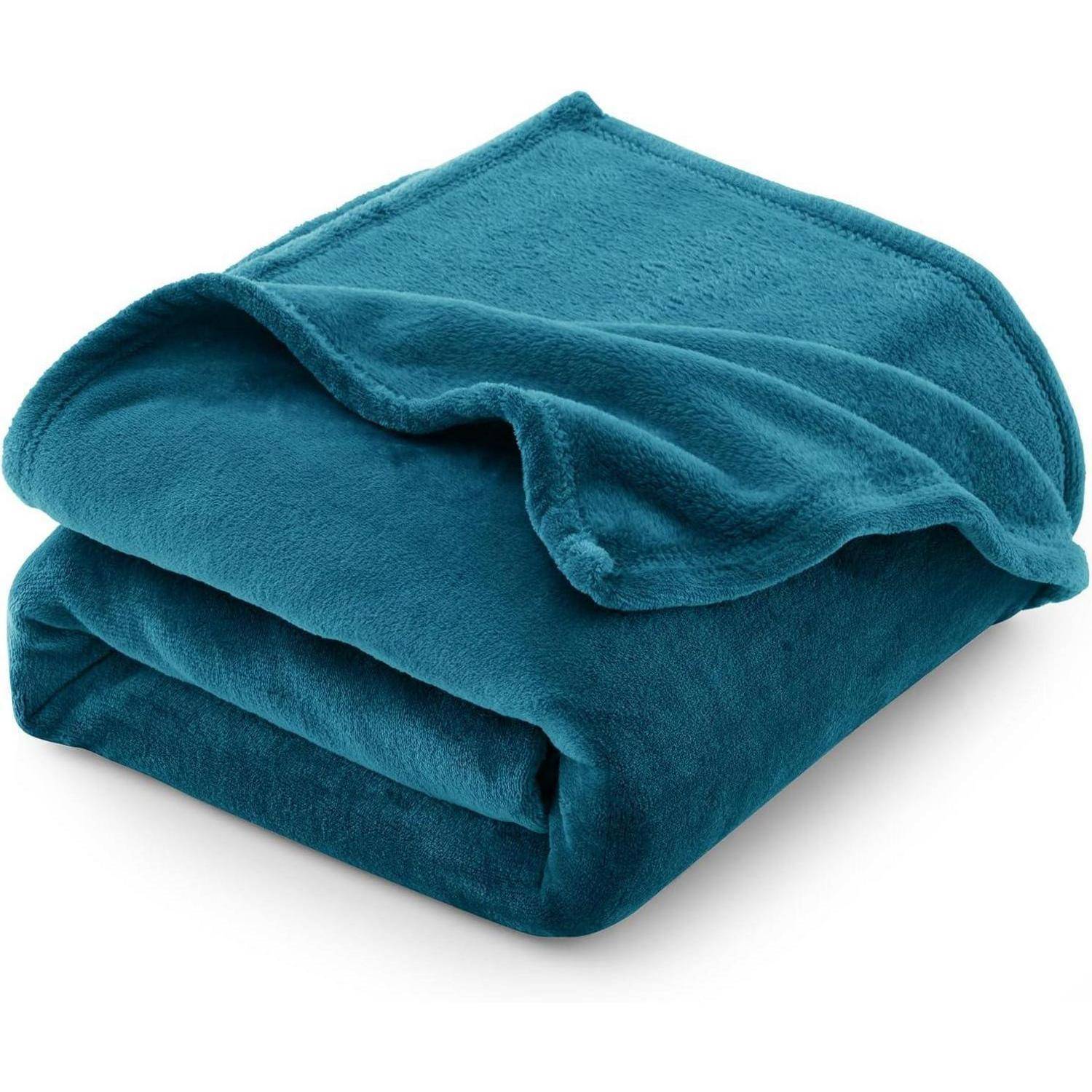 Eine petrolblaue Plüschdecke ist ordentlich gefaltet und zeigt ihre weiche Textur und glatte Oberfläche.
