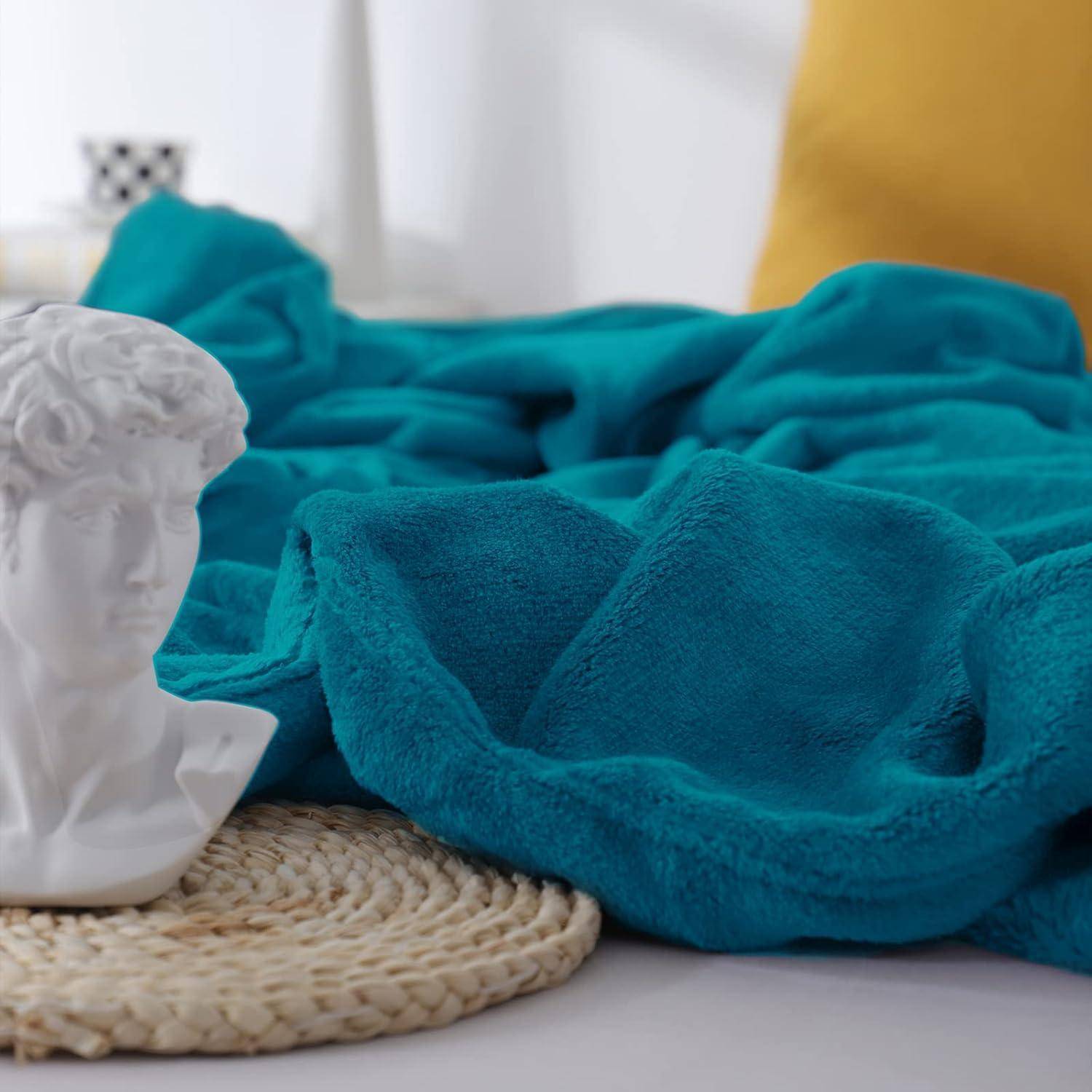 Eine weiße Büste-Skulptur auf einer runden geflochtenen Matte, umgeben von einem blauen strukturierten Stoff. Ein gelbes Kissen ist im Hintergrund teilweise zu sehen.