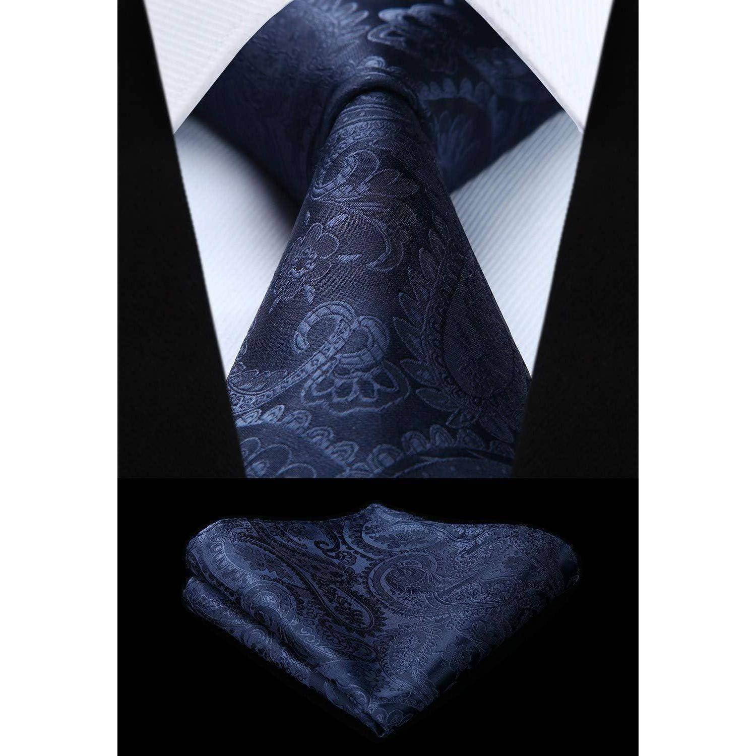 Eine marineblaue Krawatte mit Paisleymuster, kombiniert mit einem passenden Einstecktuch, präsentiert vor einem weißen Hemd.