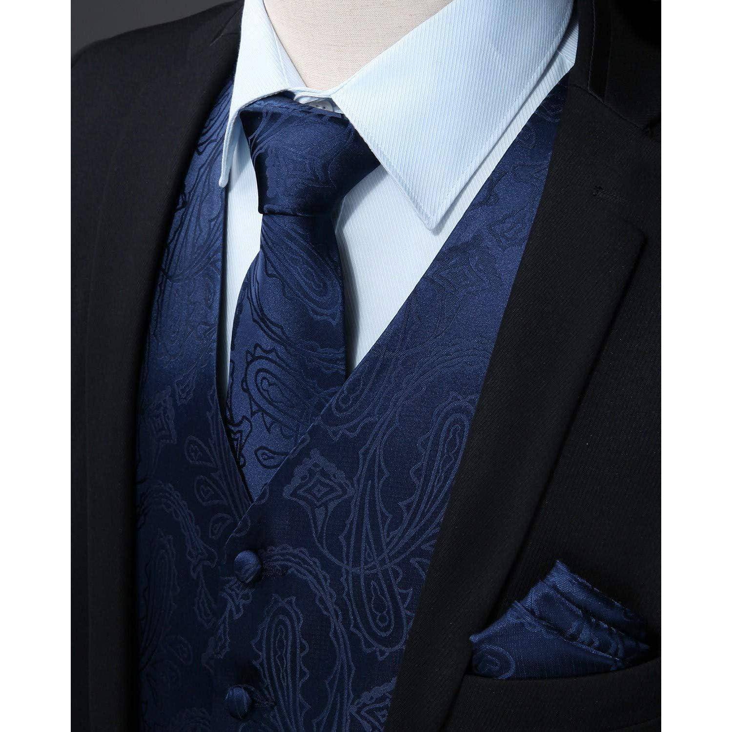 Eine Nahaufnahme der formellen Kleidung eines Mannes: schwarze Anzugsjacke, gemusterte Marineweste, passende Krawatte, hellblaues Hemd und Einstecktuch.