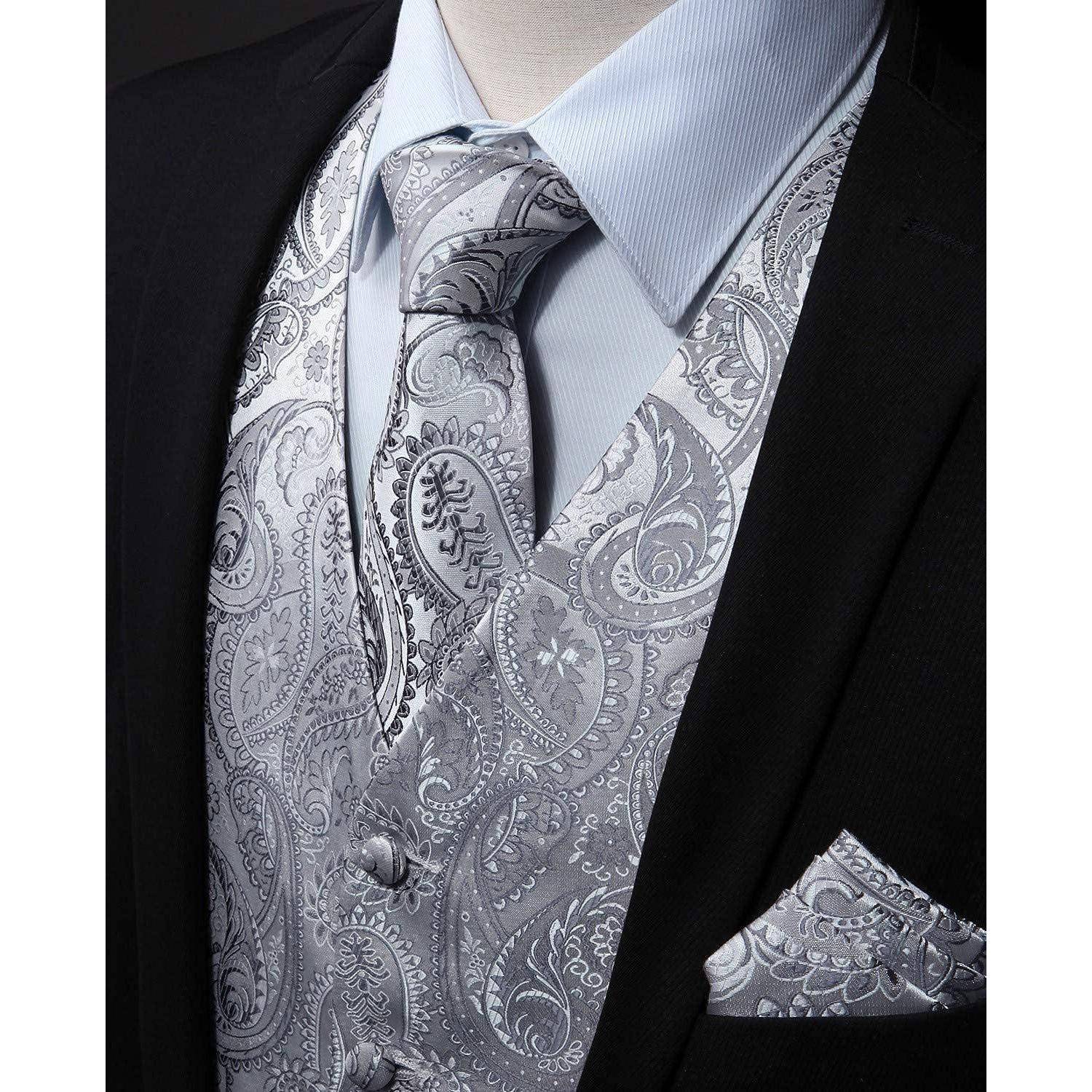 Detailaufnahme eines formellen Anzugs mit einem hellblauen Hemd, einer gemusterten silbernen Krawatte sowie einer passenden Weste und einem Einstecktuch im Paisley-Muster.