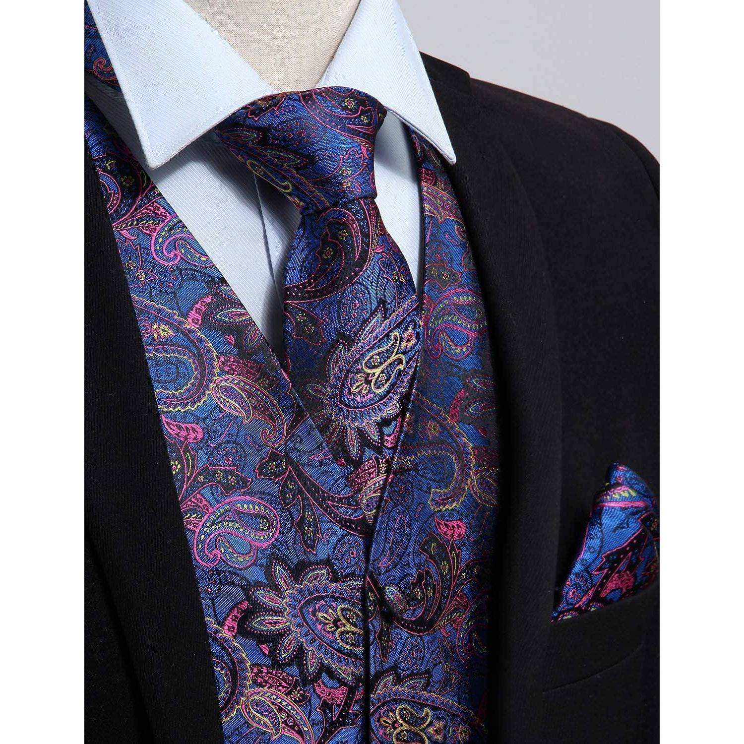 Eine Nahaufnahme einer Person, die einen dunklen Anzug mit einer lebendigen blauen Paisley-gemusterten Krawatte, Weste und Einstecktuch trägt. Das Hemd ist hellblau.