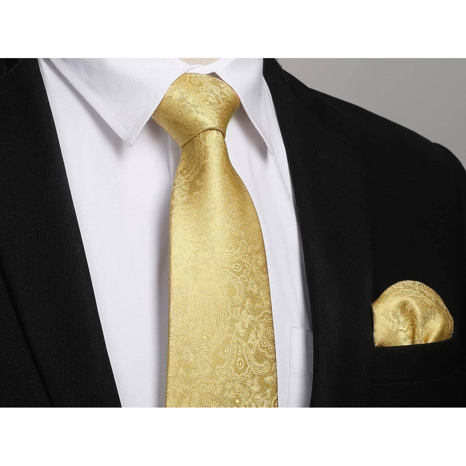 Eine Person, die einen schwarzen Anzug mit einem weißen Hemd, einer gemusterten goldenen Krawatte und einem passenden goldenen Einstecktuch trägt.