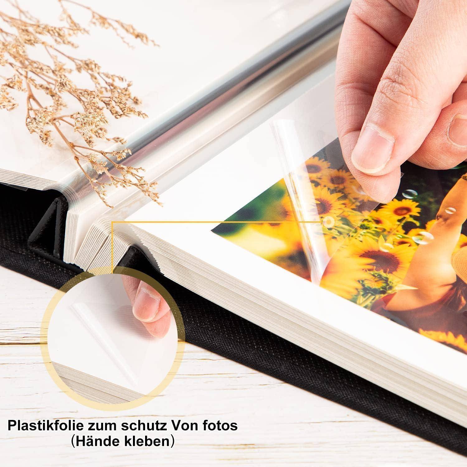 Eine Hand schiebt ein Foto in eine Schutzalbumseite. Text lautet: 'Plastikfolie zum Schutz von Fotos (Hände sauber halten)'. Getrocknete Blumen befinden sich in der Nähe.