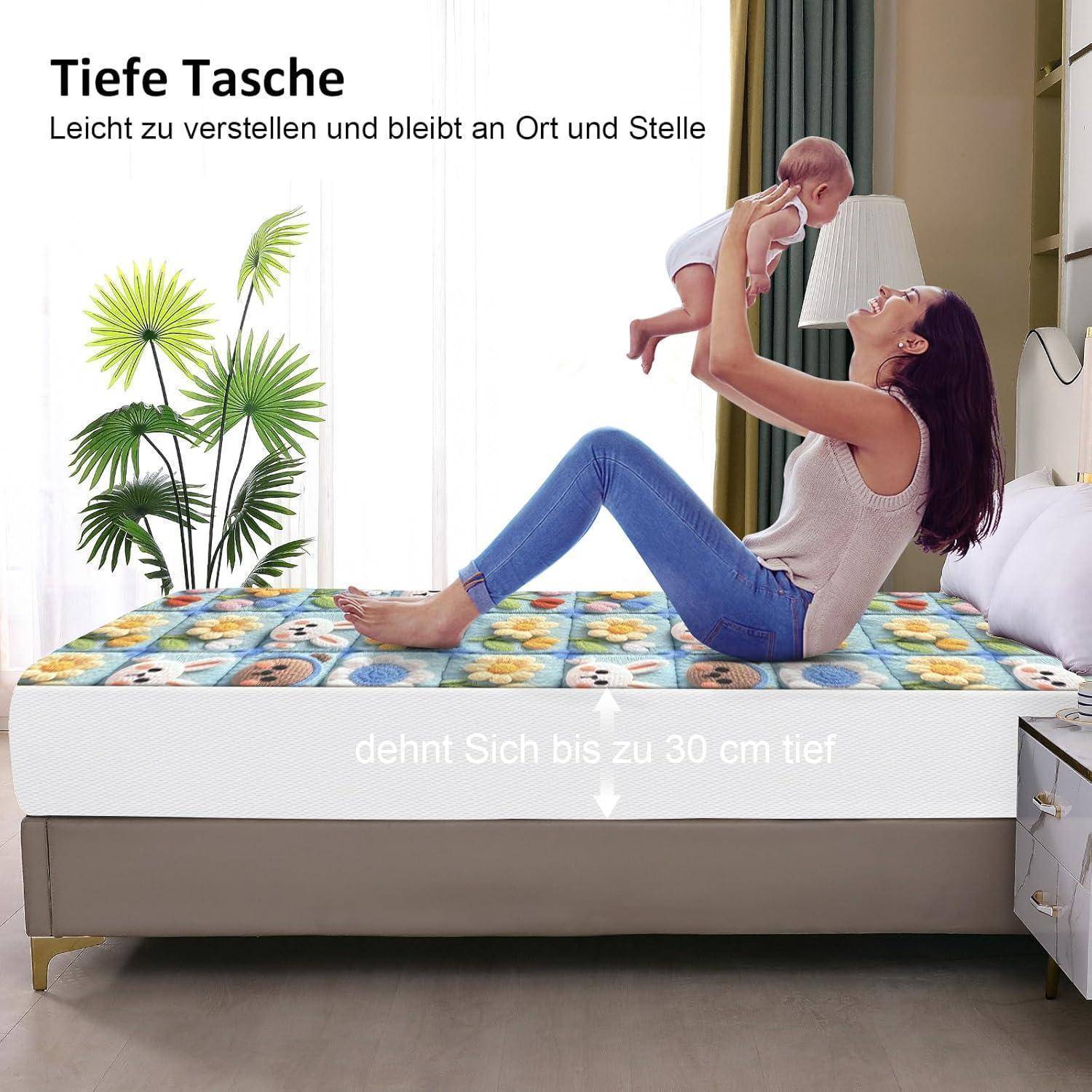Eine Frau sitzt auf einer bunten Tagesdecke und hebt ein Baby freudig in die Luft. Text oben liest sich: 'Tiefe Tasche' und 'Leicht zu verstellen und bleibt an Ort und Stelle.