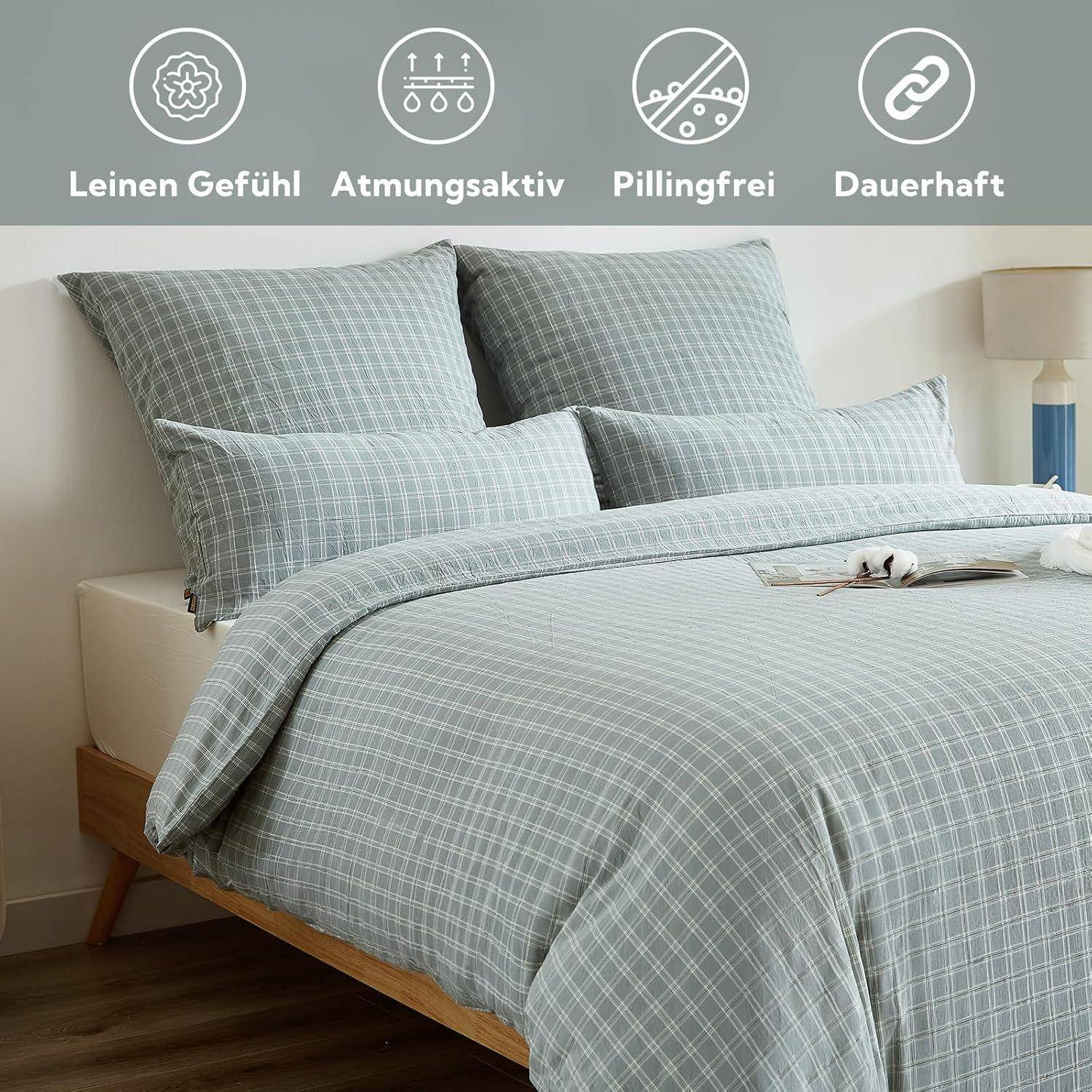 Ein ordentlich gemachtes Bett mit karierter Bettwäsche in sanften Grautönen. Über dem Bild befinden sich Icons, die folgende Eigenschaften hervorheben: „Leinen-Optik, atmungsaktiv, pillingfest, langlebig