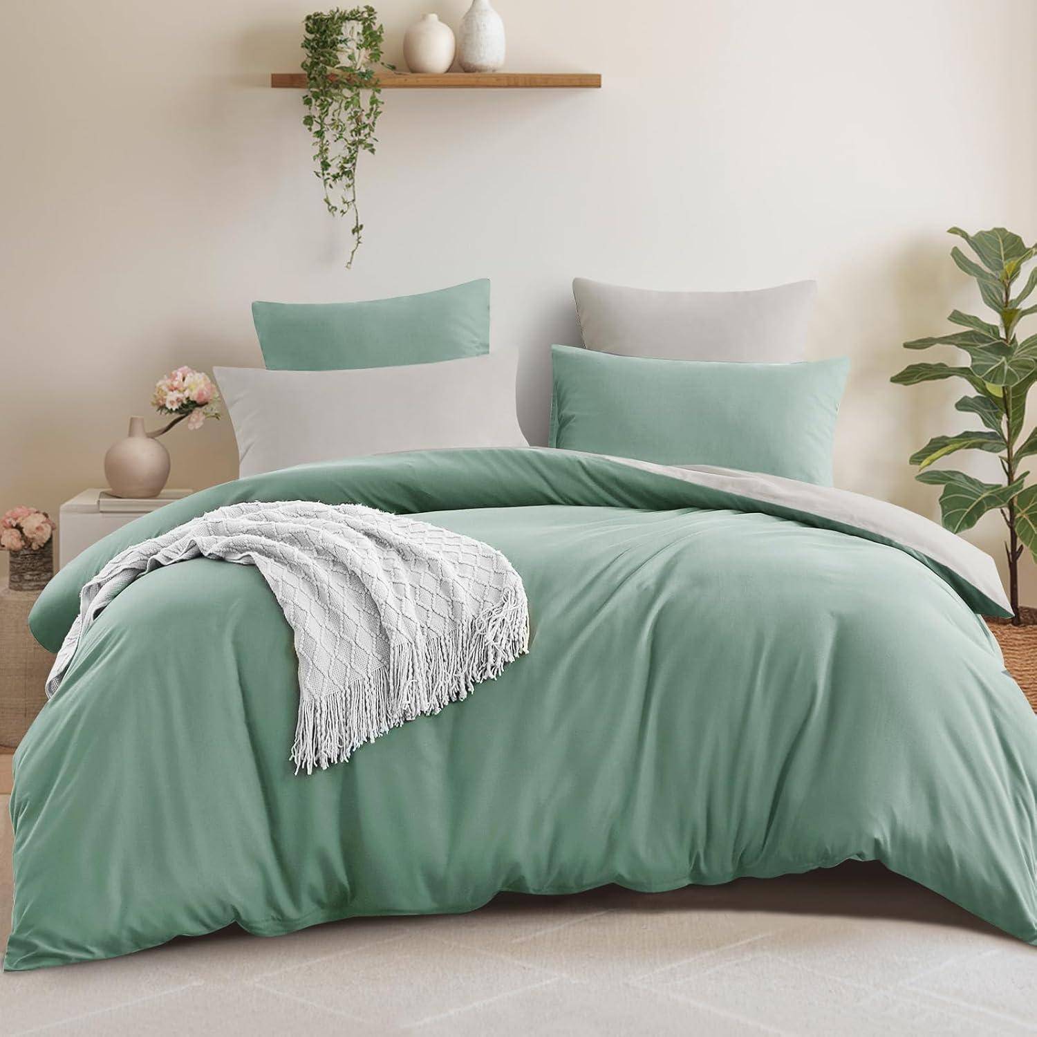 Ein Schlafzimmer mit einem ordentlich gemachten Bett, das mit grüner Bettwäsche, zwei Kissen und einem dekorativen weißen Überwurf ausgestattet ist. Im Hintergrund befinden sich eine Pflanze und Regale.