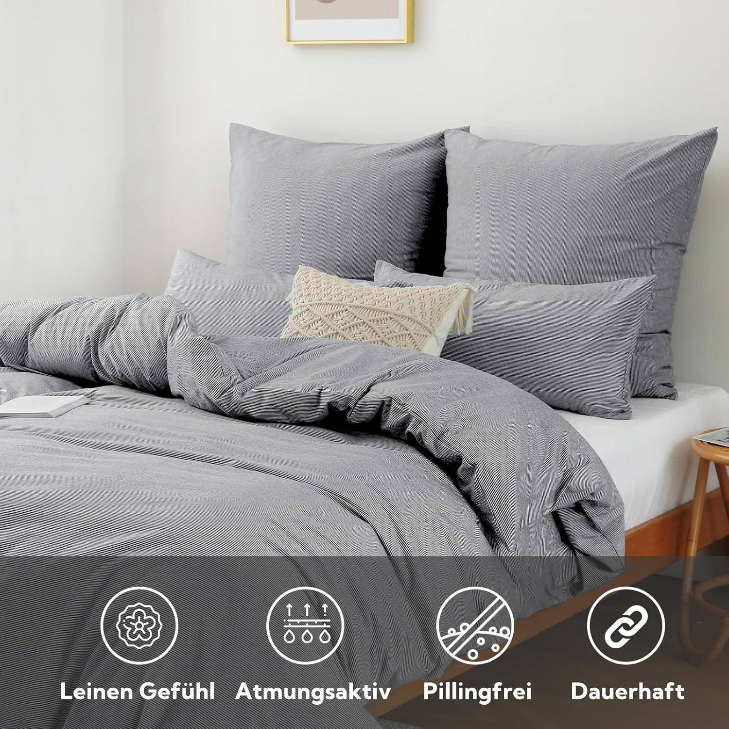 Ein sorgfältig gemachtes Bett mit grauen Bettwäsche, Kissen und einem kleinen beigen Kissen, mit Hervorhebung der Eigenschaften: Leinengefühl, atmungsaktiv, keine Pillingbildung, langlebig.