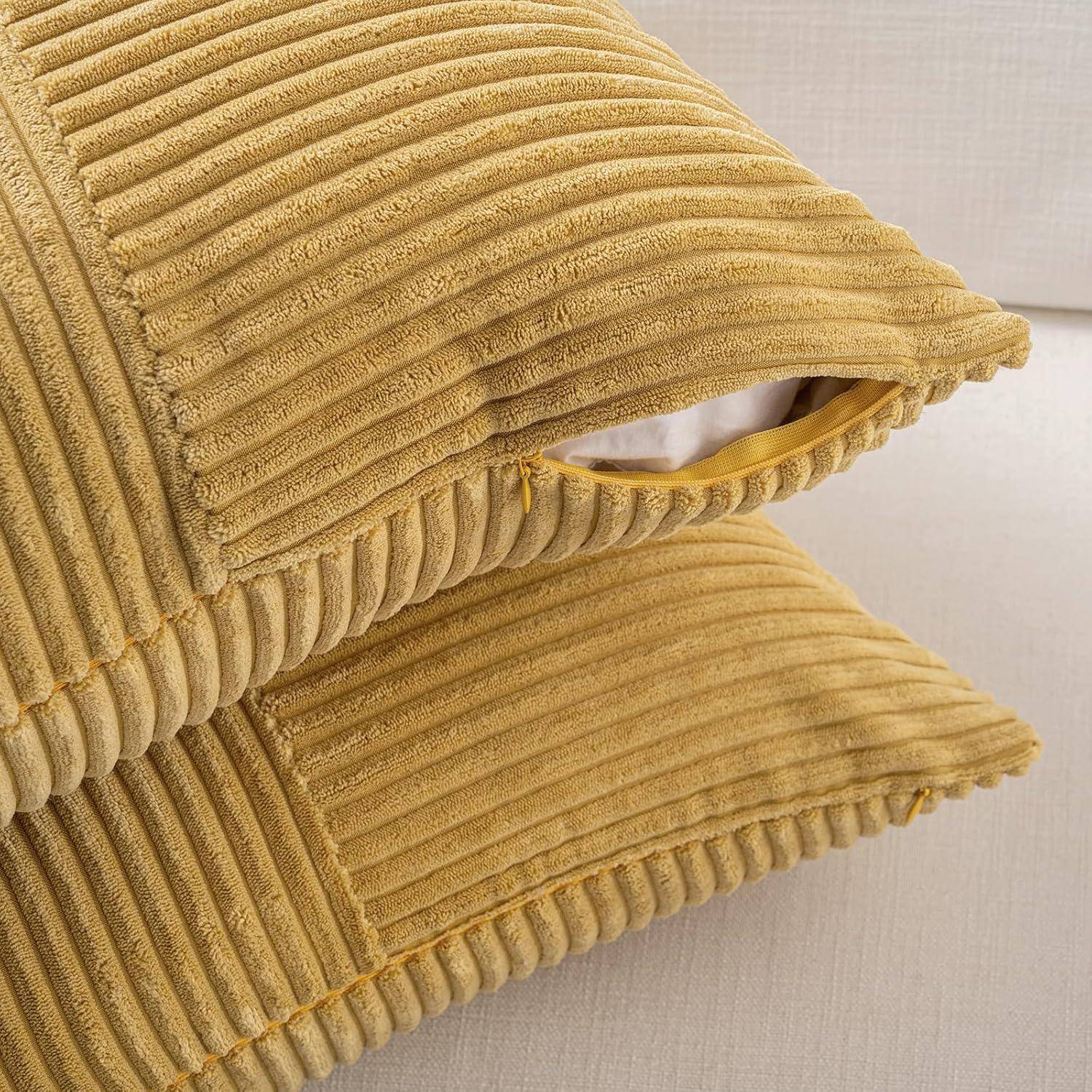 Nahaufnahme von zwei gestapelten, gelben gerippten Kissen auf einem beigen Sofa, die die Textur und das Reißverschlussdetail des Stoffes hervorheben.