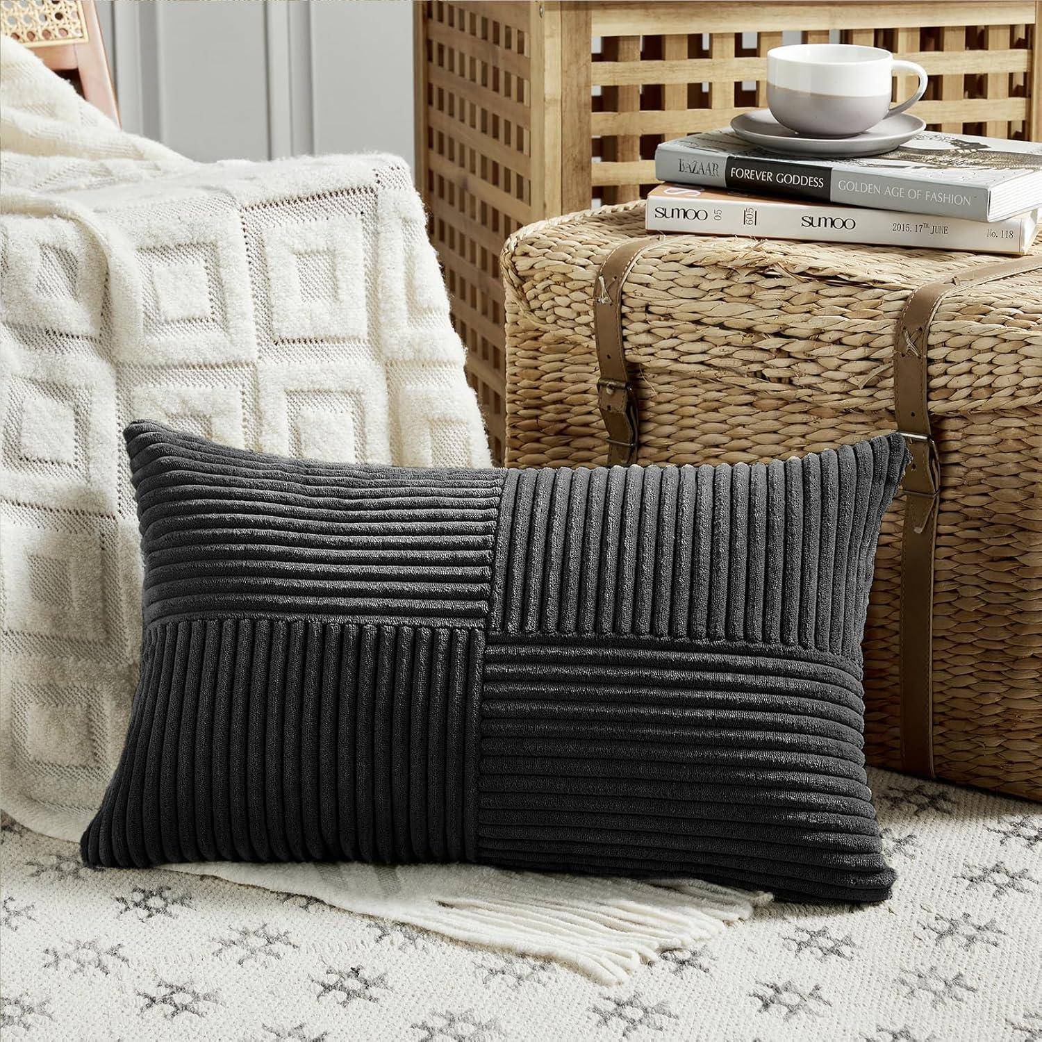 Ein gemütliches Zimmer zeigt ein strukturiertes schwarzes Kissen auf einem hellen Teppich, neben einem gewebten Korb mit Büchern und einer dampfenden Tasse, wodurch eine entspannende Atmosphäre entsteht.