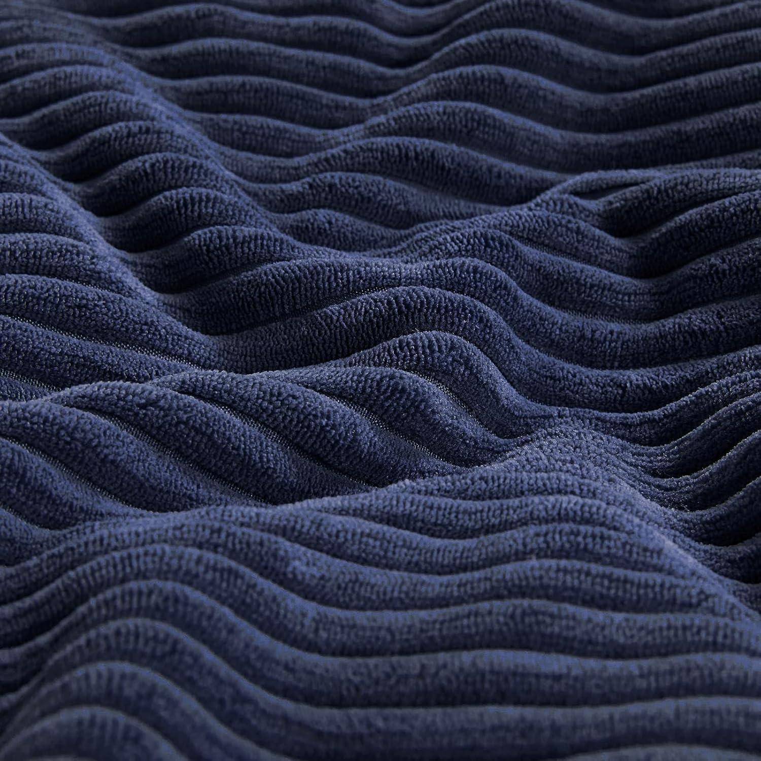 Nahaufnahme einer gewellten, marineblau gefärbten Gewebetextur, die ein welliges Muster und weiches Material zeigt und Komfort und Wärme vermittelt.