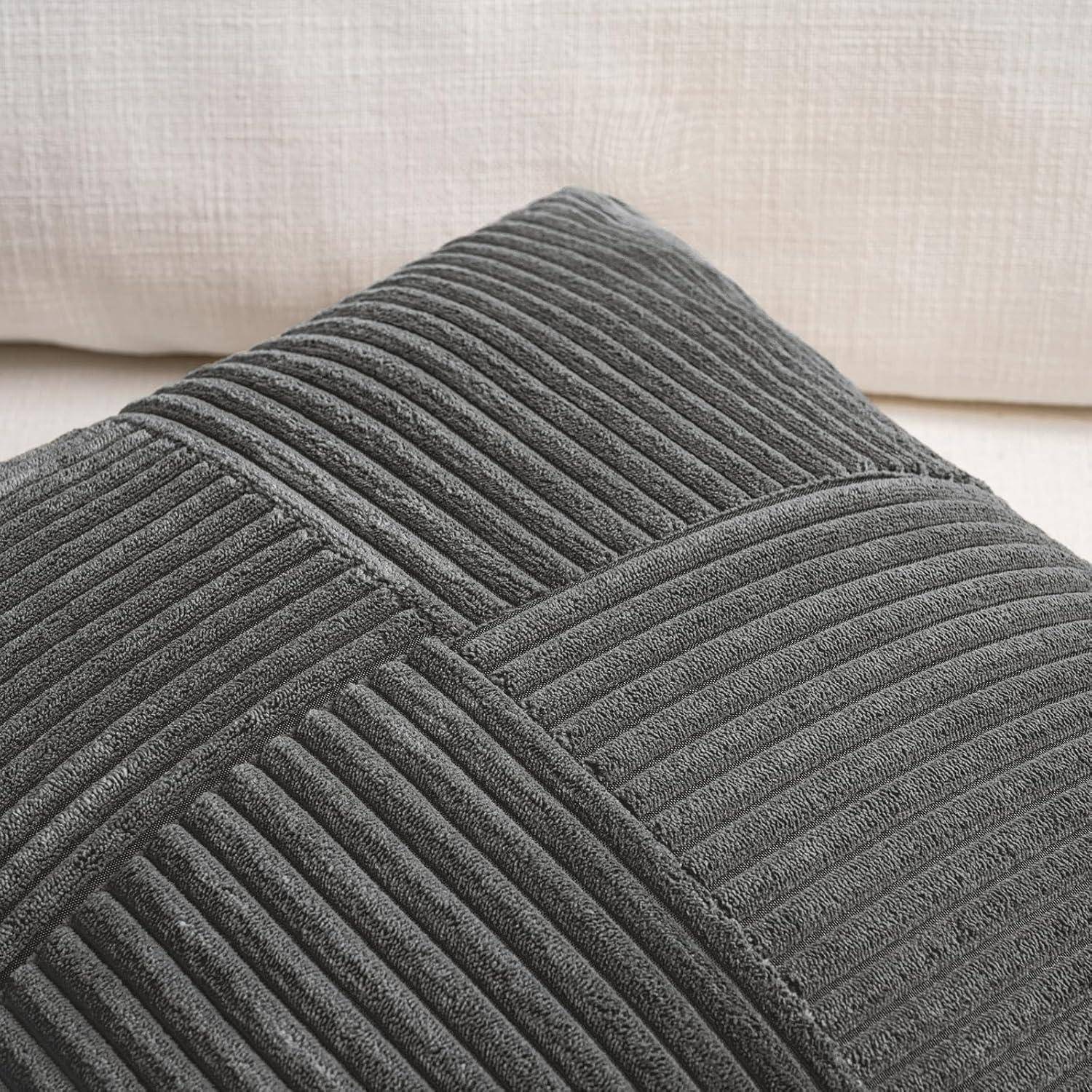 Grauer Cordstoff-Kissenbezug auf einem beigen Sofa, der die Gewebestruktur und den Texturkontrast hervorhebt.