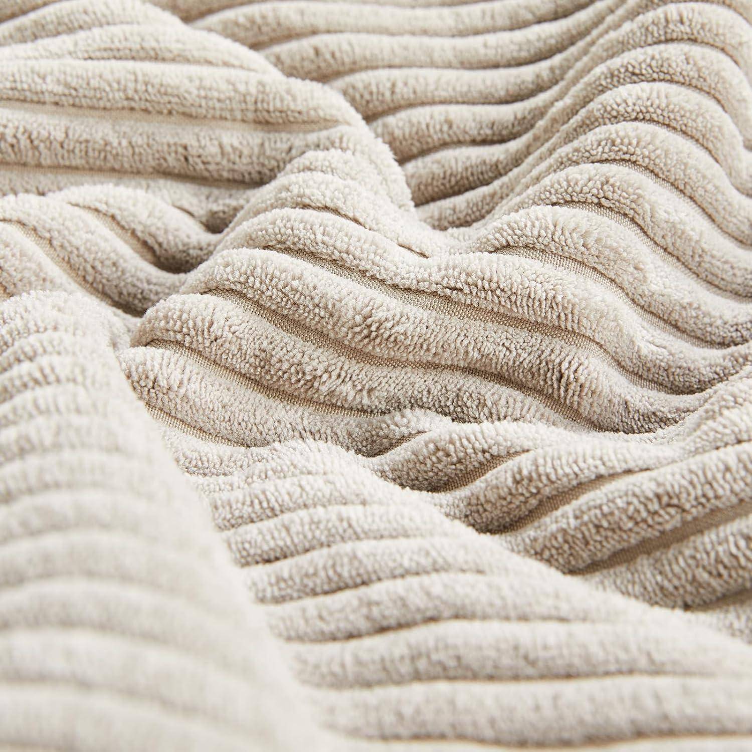 Strukturierter, beiger Stoff mit wellenförmigen, parallelen Linien, die einen weichen, wellenartigen Effekt erzeugen.