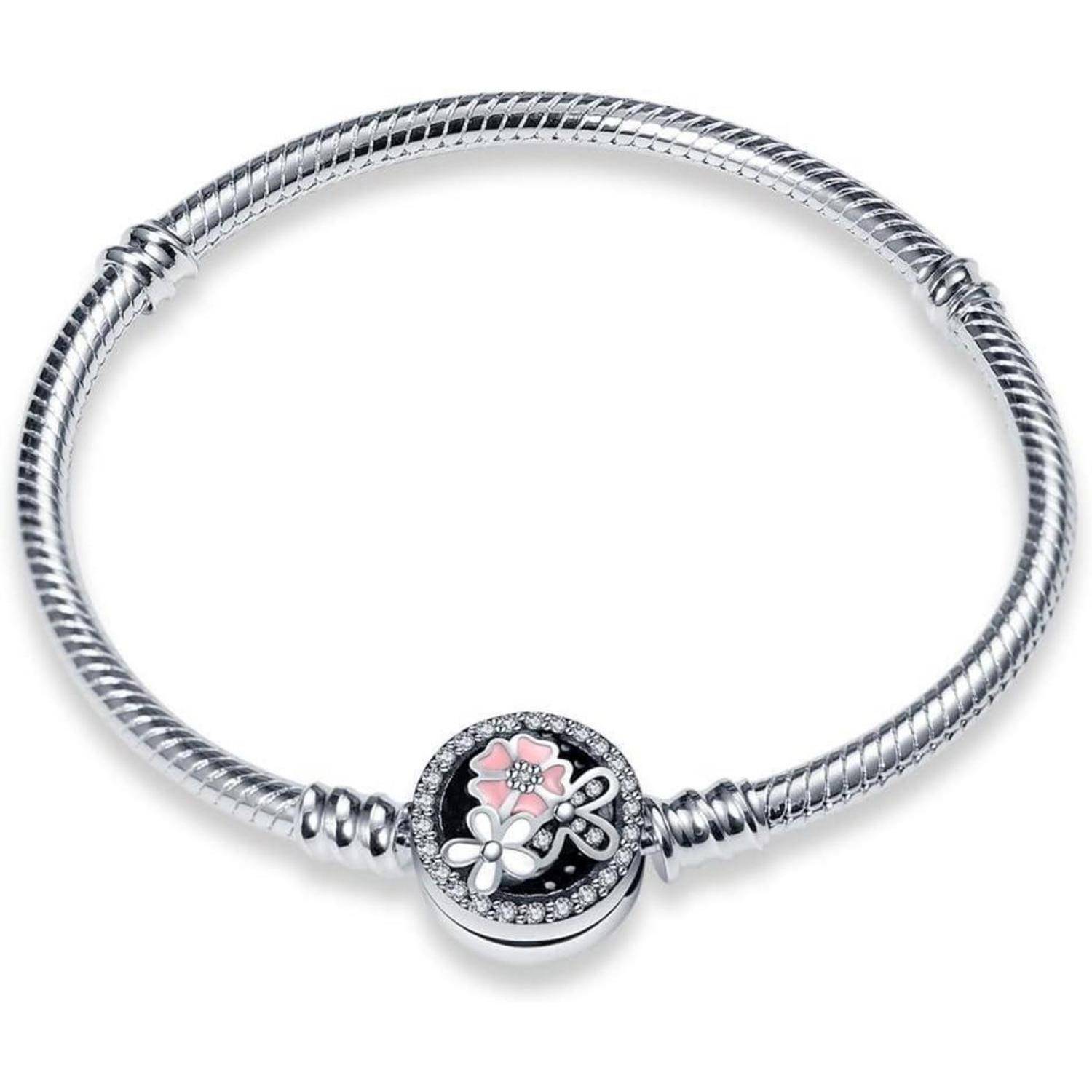 Ein silbernes Armband mit einem runden Anhänger, der eine rosa Blume und kleine silberne florale Akzente zeigt, vor einem schwarzen Hintergrund mit funkelnden Steinen.