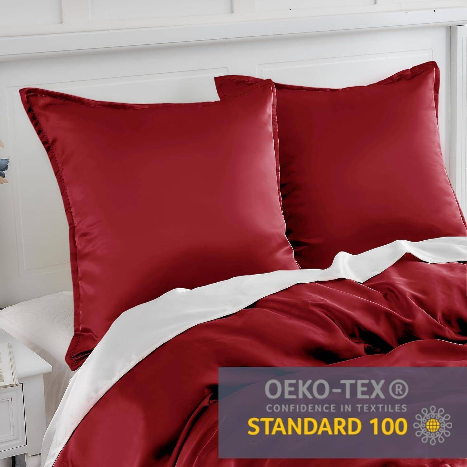 Ein ordentlich gemachtes Bett mit roten Satin-Kissen und einer Decke, versehen mit einem OEKO-TEX Standard 100 Etikett, das die Textielsicherheitszertifizierung kennzeichnet.