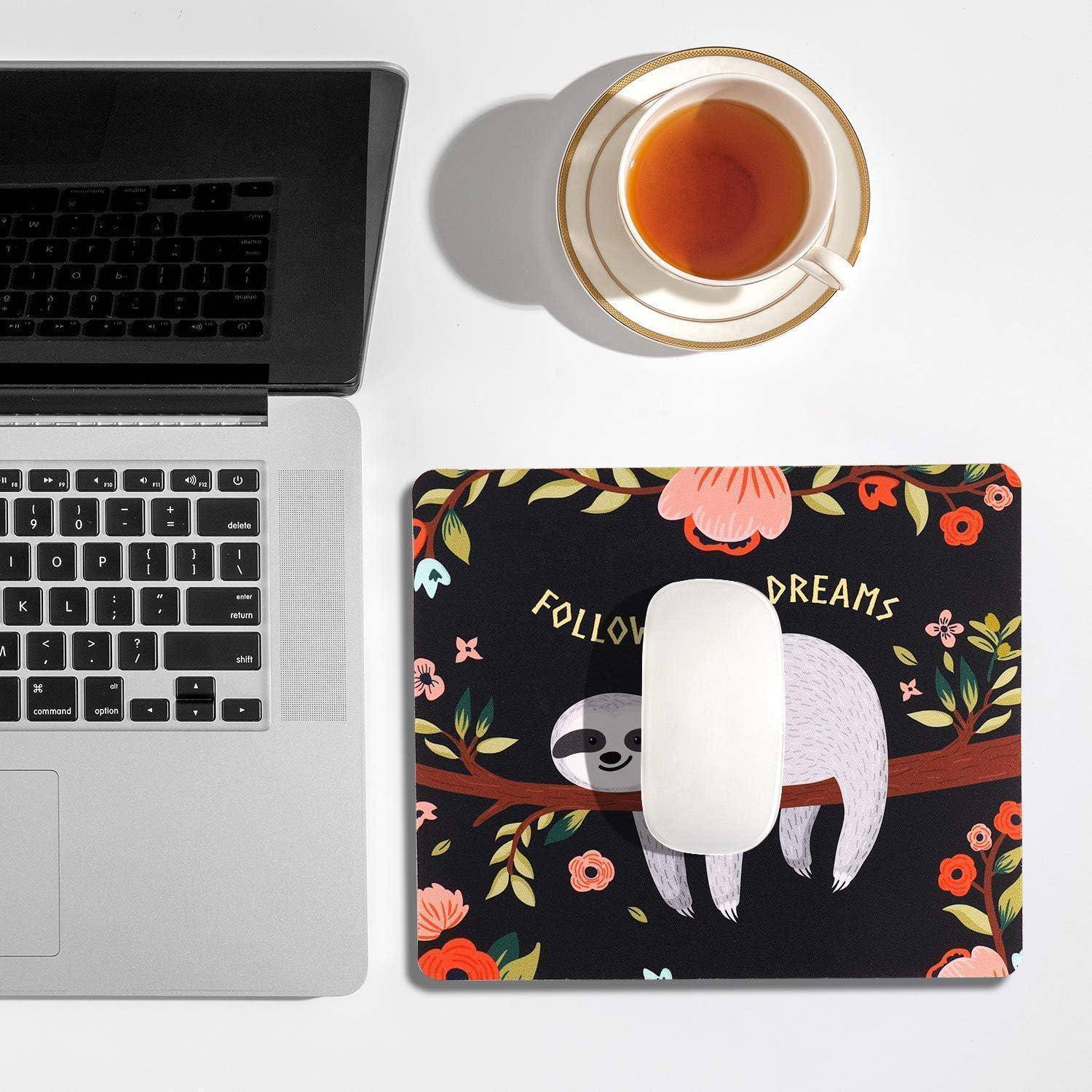 Ein Laptop neben einem Mousepad mit einem Faultier, das an einem Ast hängt, und den Worten 