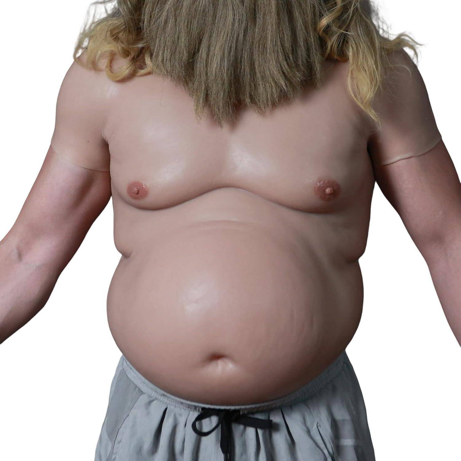 Eine Person, die ein realistisches Oberkörper-Kostüm trägt, das ein bärtiges Gesicht und einen hervorstehenden Bauch umfasst, kombiniert mit grauen Shorts.